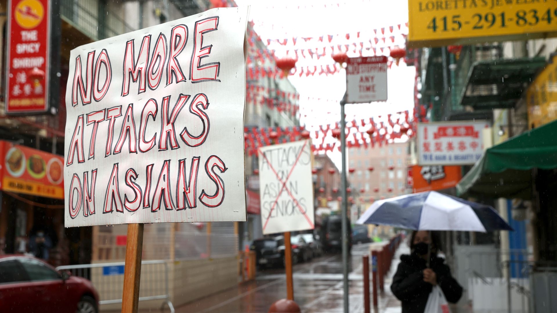 Photo of a sign that says "No more attacks on Asians" standing in a SF Chinatown street decorated with red lanterns