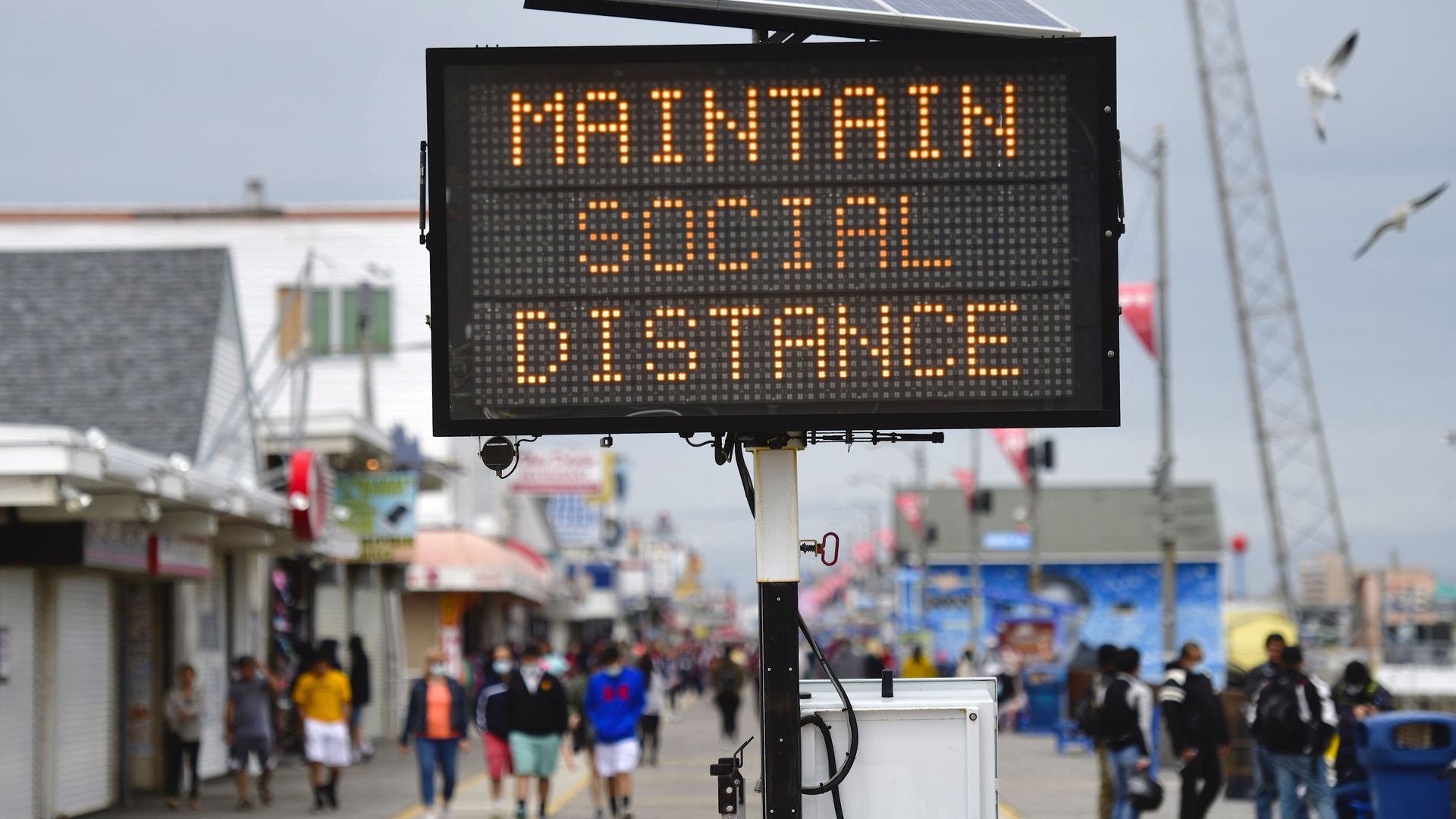 A sign placed on the boardwalk states "MAINTAIN SOCIAL DISTANCE" on May 24, 2020 in Wildwood, New Jersey.