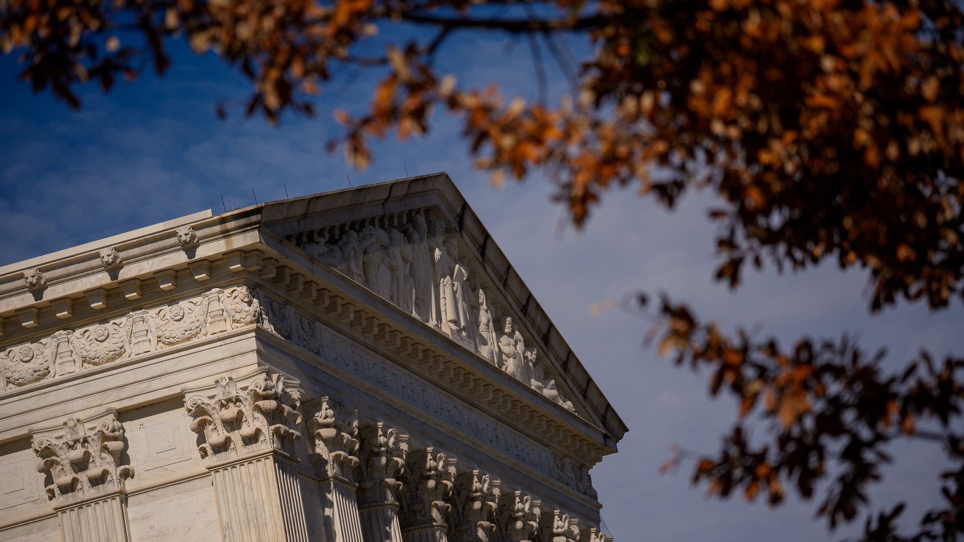 The Supreme Court building, with orange leaves peeking into the sky
