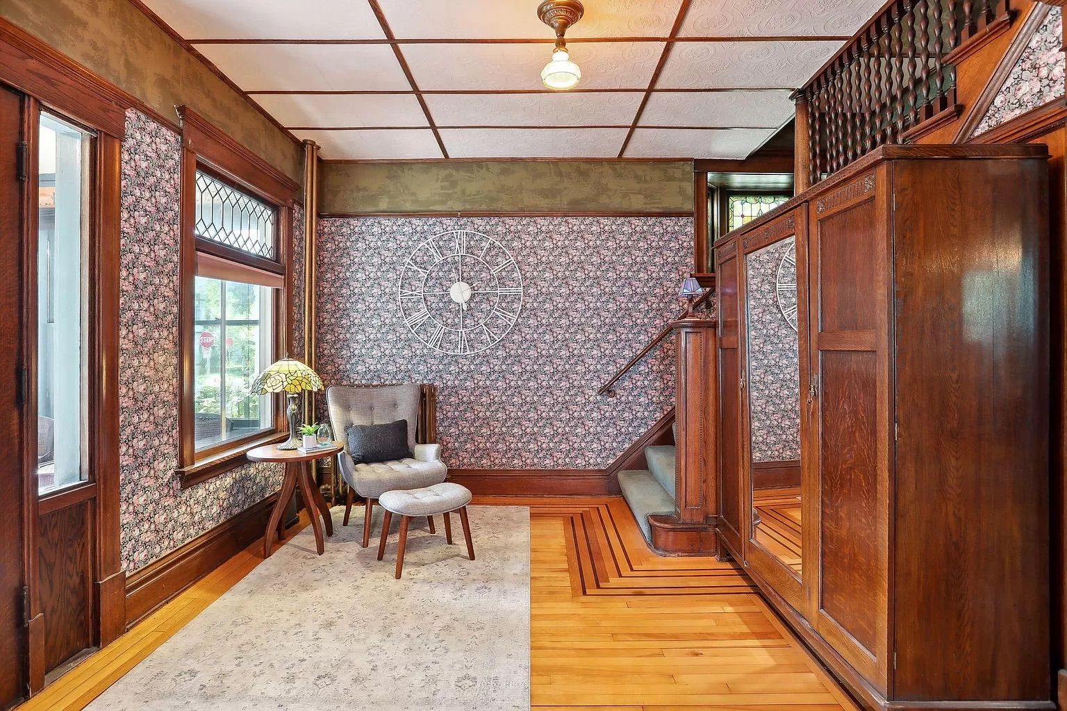 An entryway with colorful patterned wallpaper and wood accents.