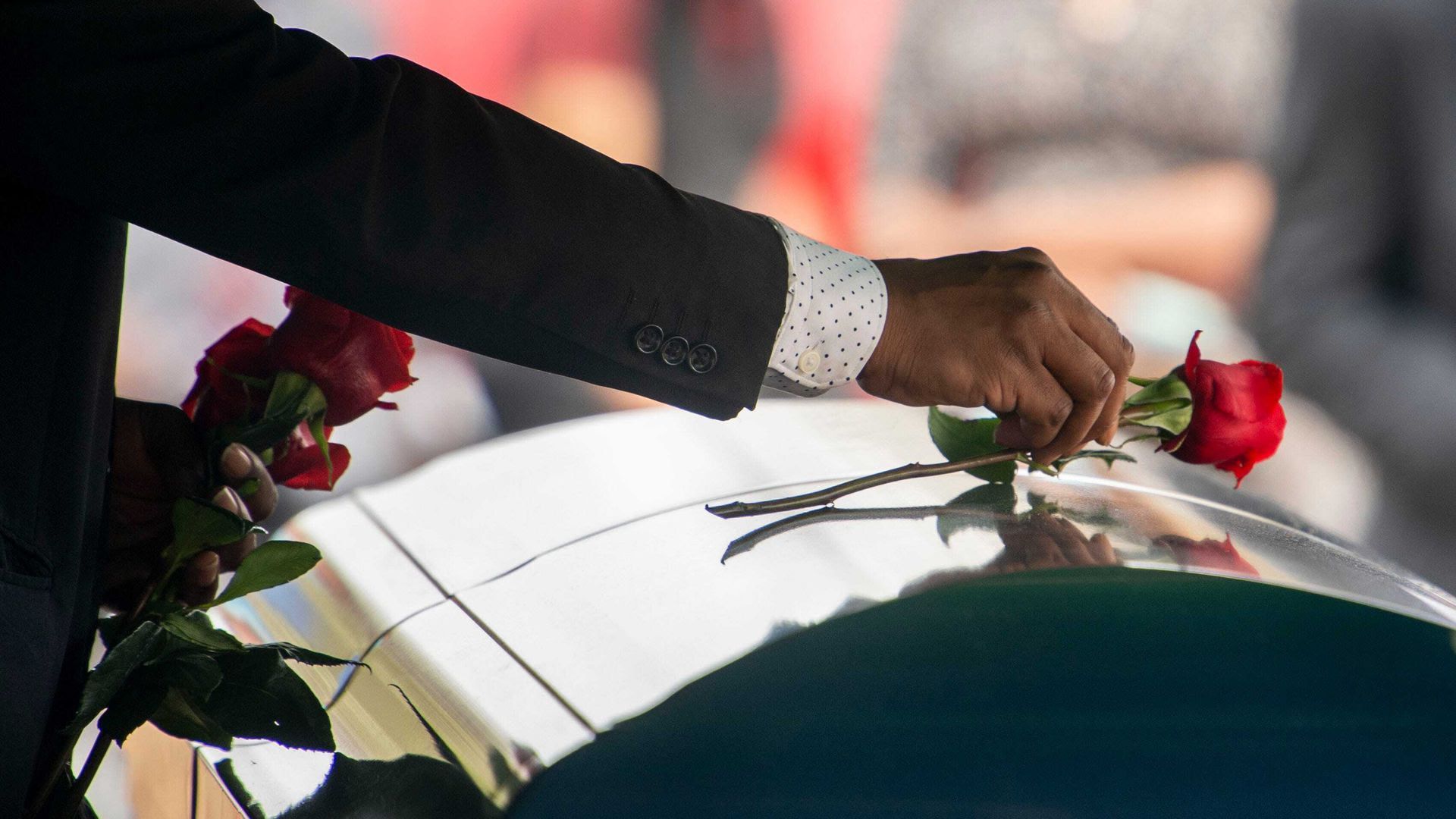 A mourner places roses on the casket at the funeral for Terry Childress, who was killed last year at Trousdale Turner Correctional Center.