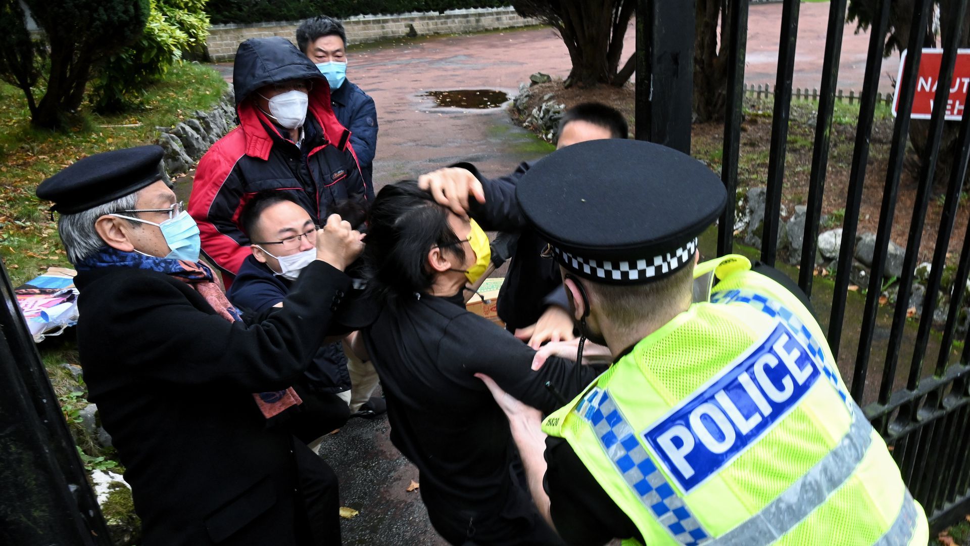 Police intervene as a man is pulled at the gate of the Chinese consulate in Manchester, northwest England, following a protest on Sunday. Photo: Matthew Leung/The Chaser News