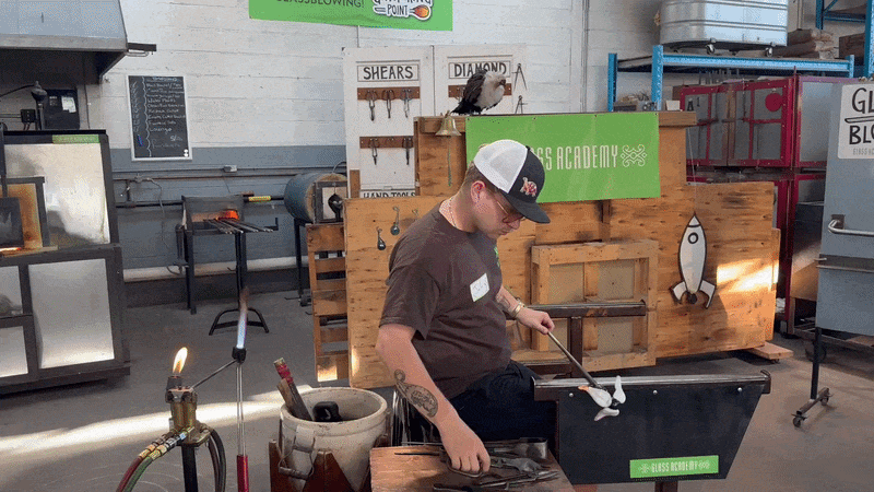 A gif of a glassblowing artist at work, clipping a piece of glass and then putting it in the heated chamber