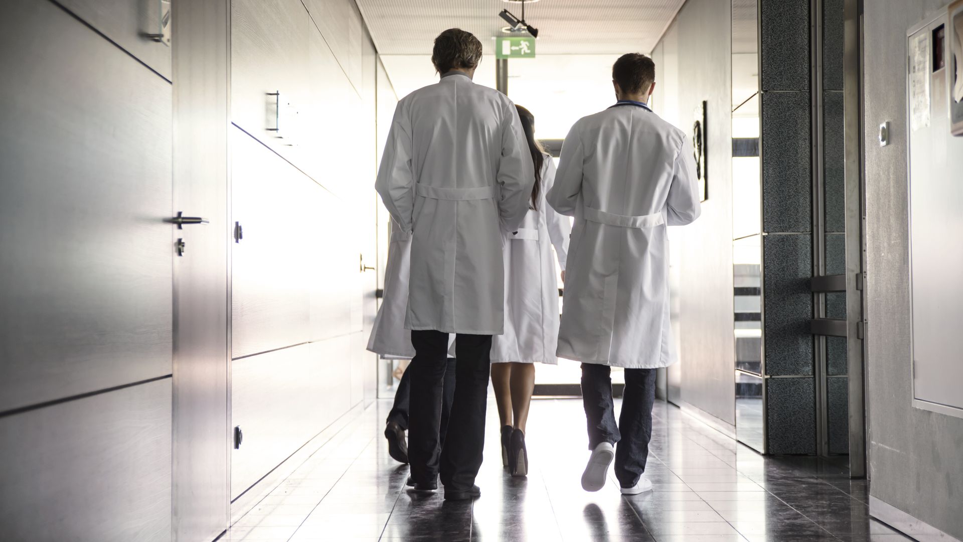 team of doctors walking in hospital hallway