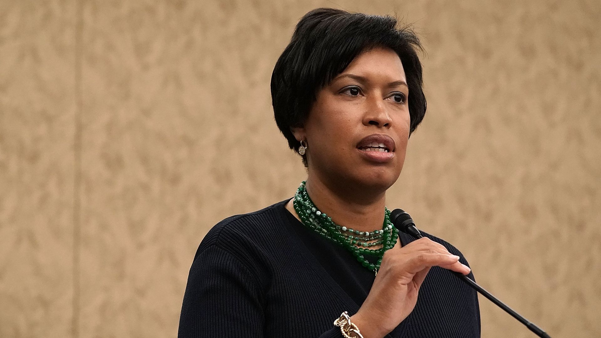 Mayor Muriel Bowser speaks into a microphone at a podium