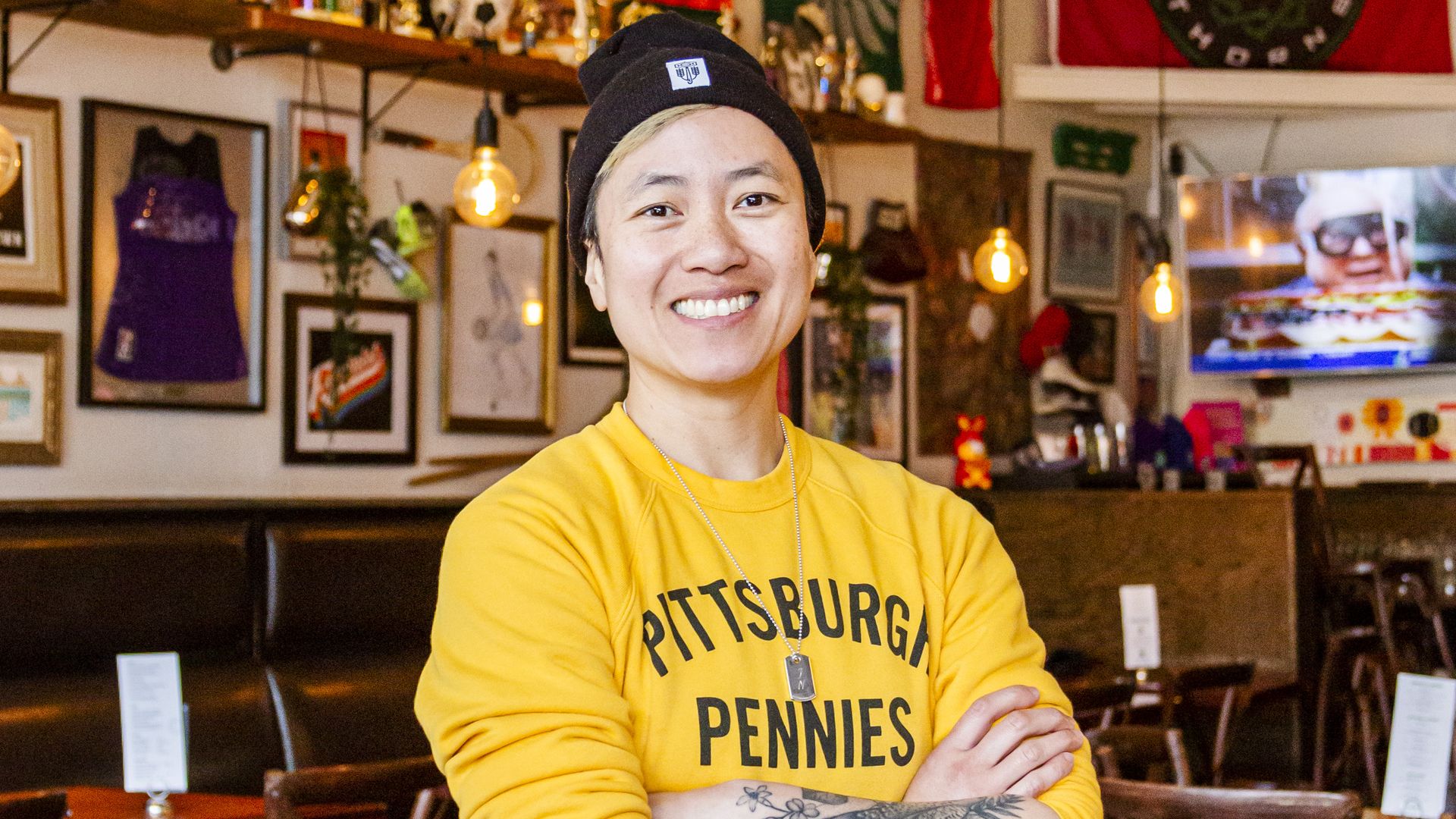 A photo of a person with their arms crossed and smiling.