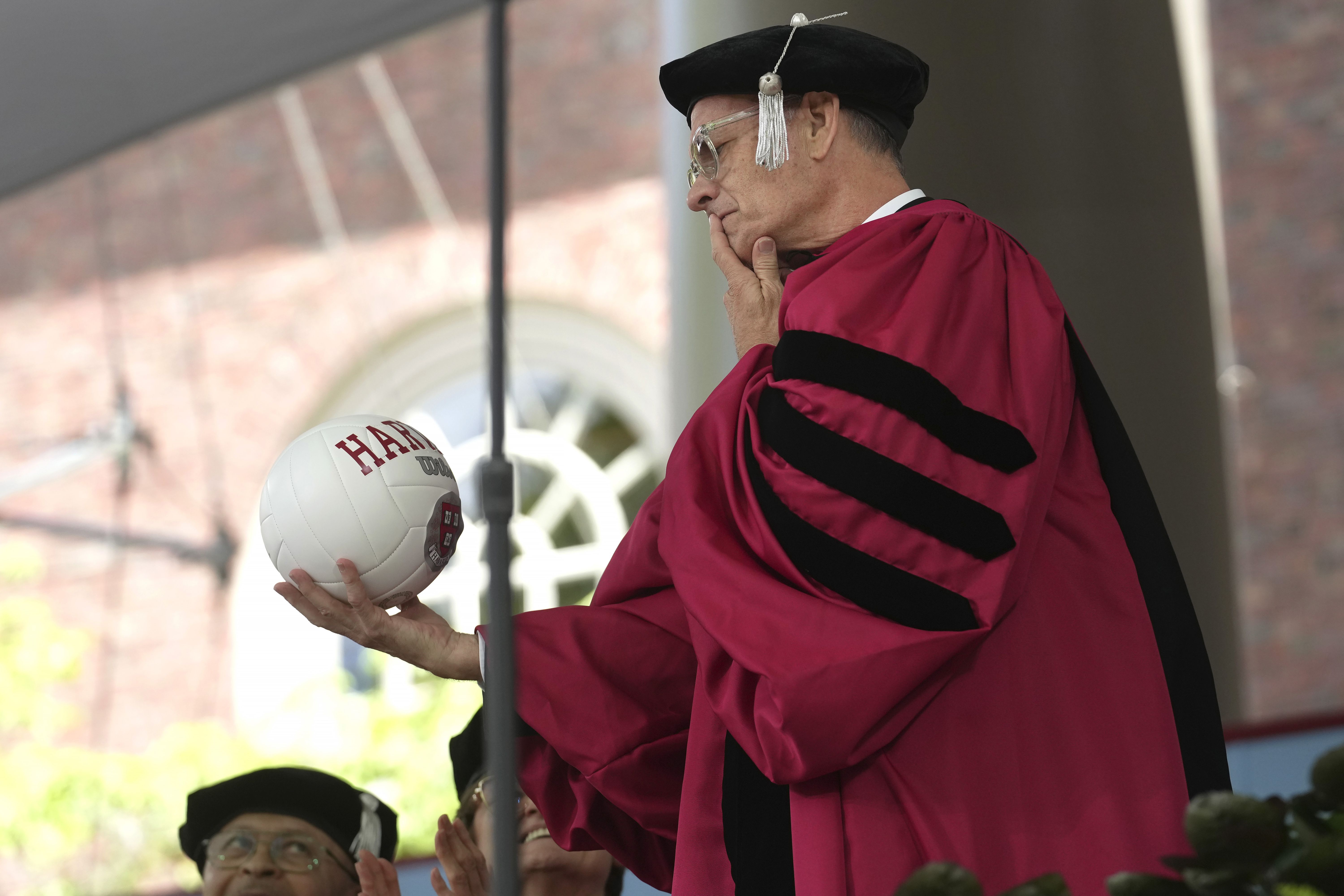 Actor Tom Hanks examines a ball as part of a spoof during Harvard University commencement exercises on the school's campus.