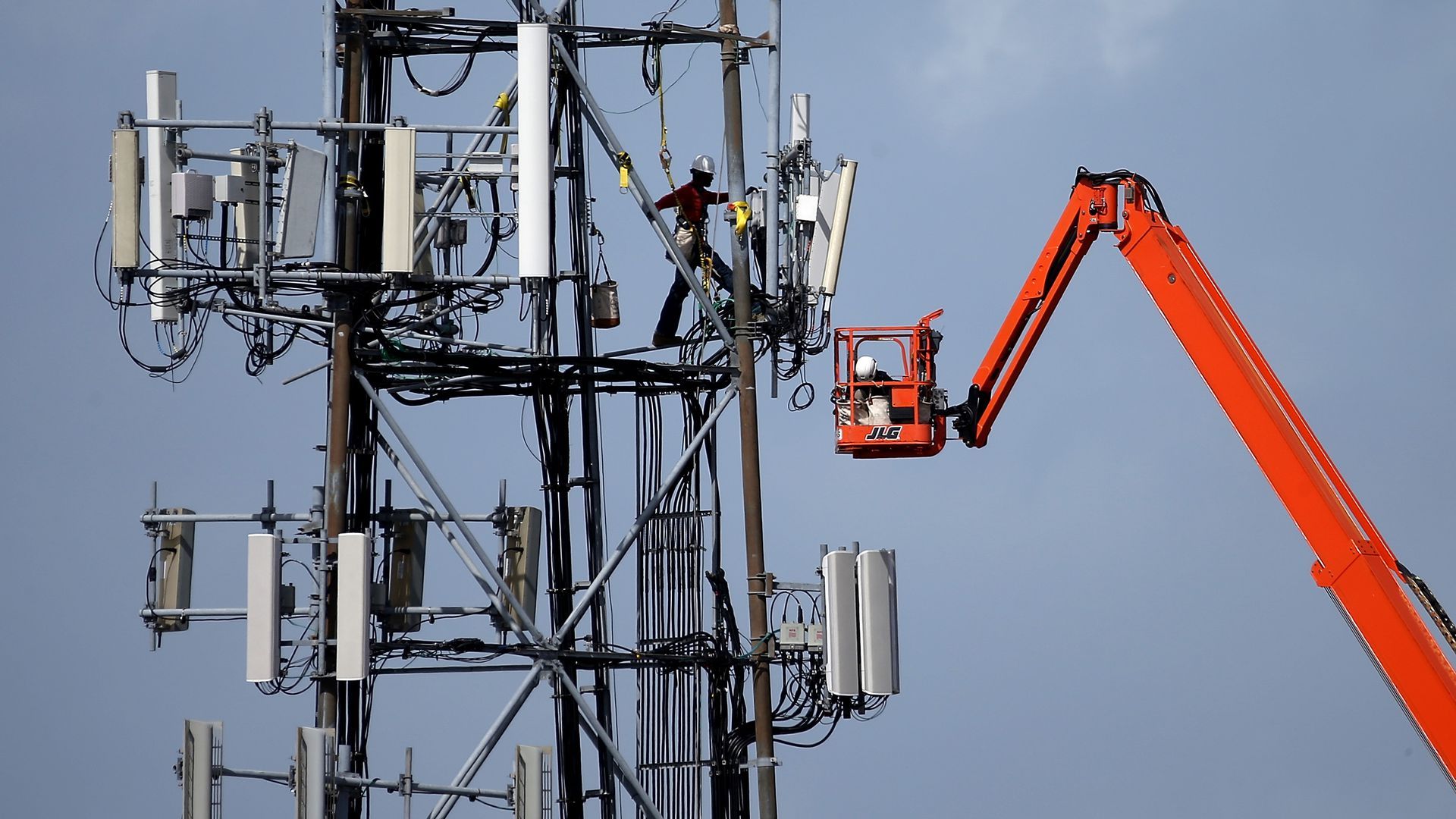 A worker climbs a cellular communications tower in Oakland, Calif.