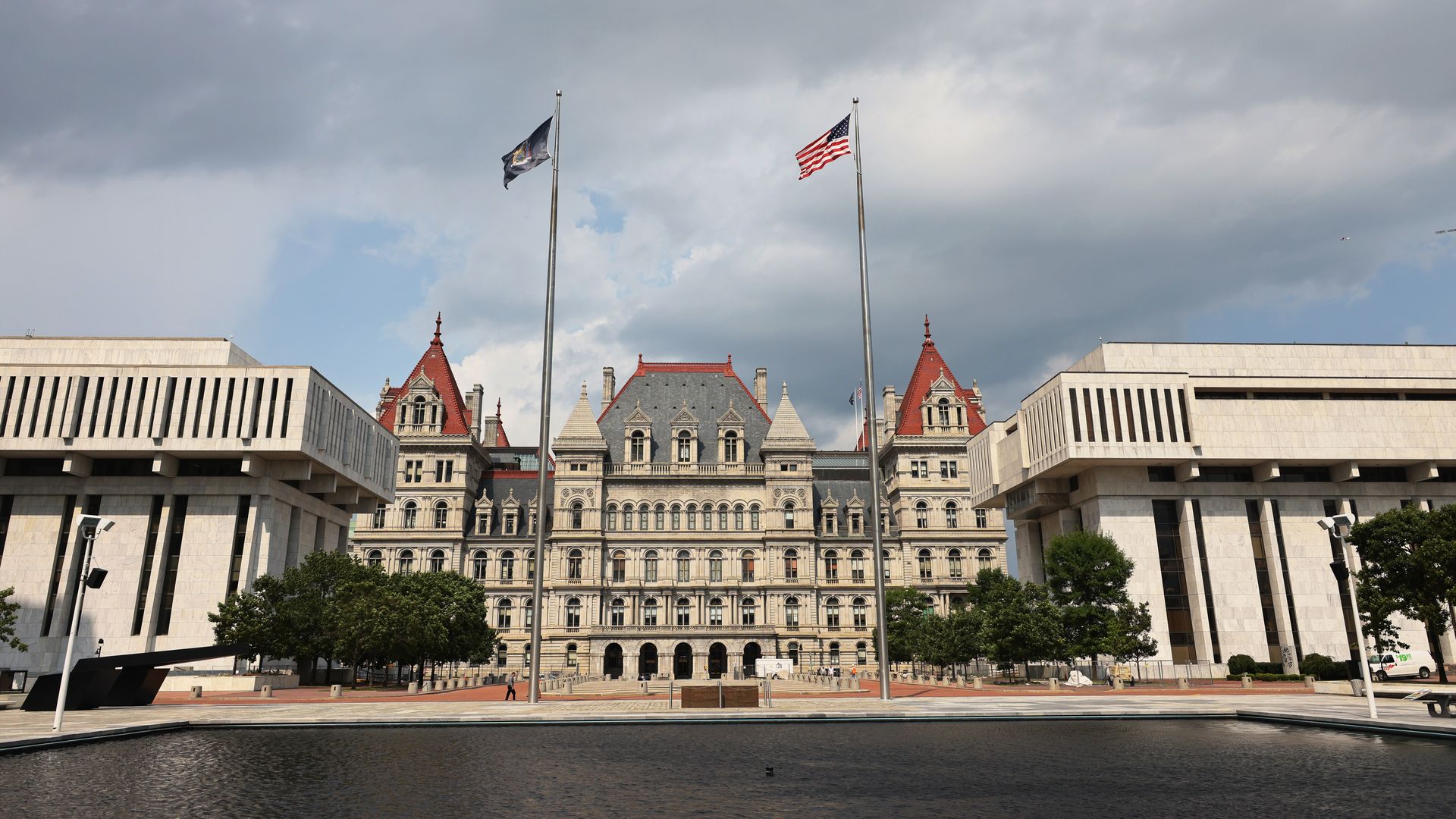 Photo of the New York state capitol building, with the American and New York flags flying in front