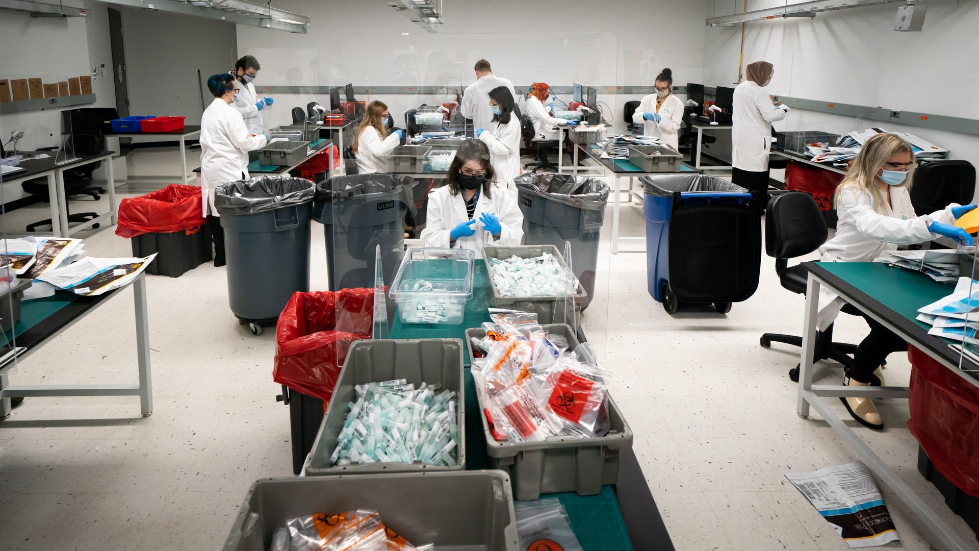 Workers sort through vials at IBX's COVID-19 spit test processing facility in Oakdale, Minnesota.