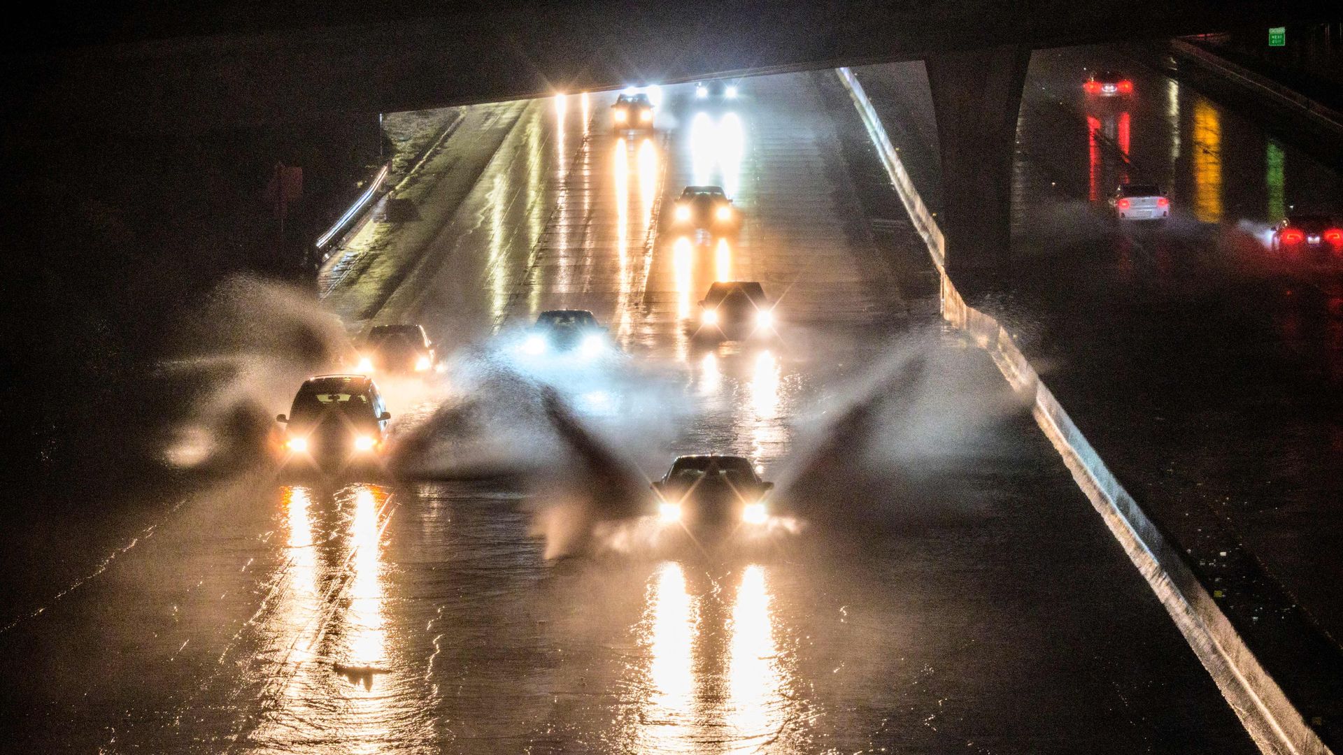 Cars attempt to drive through flooded roadways during a storm in California in Jan. 2023.