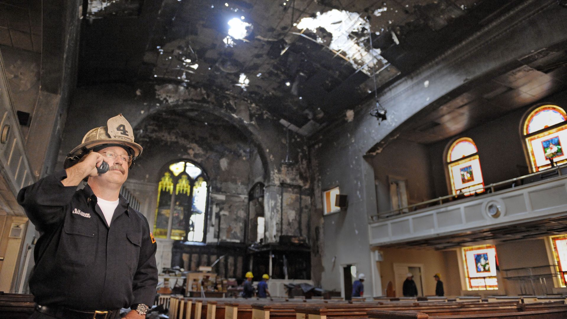 Fire Lt. Sean Egan makes a cell phone call in the burned out interior of Meridian Hill Baptist church.