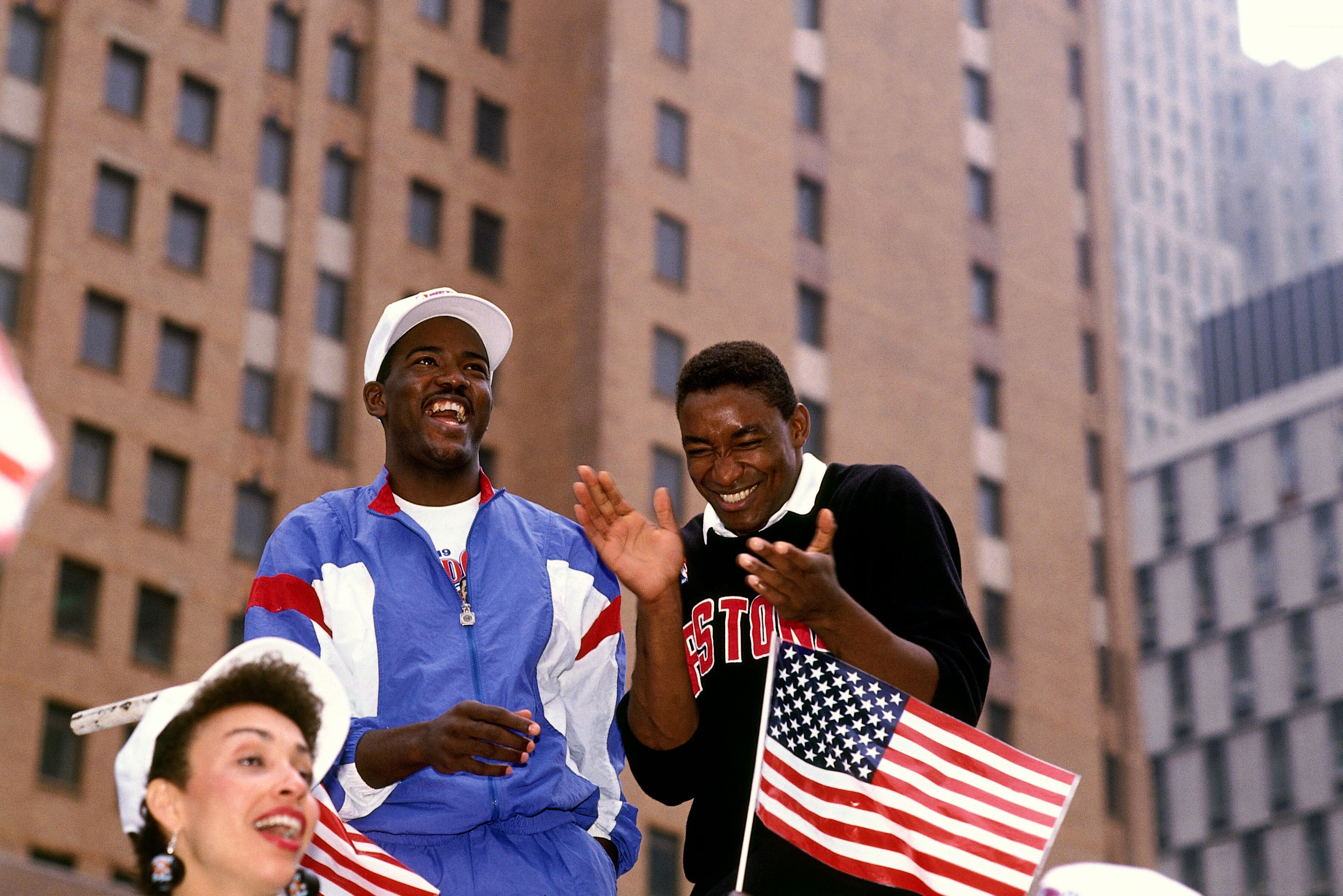  Isiah Thomas #11 and Joe Dumars #4 of the Detroit Pistons share a laugh during the Detroit Pistons Victory Parade following their sweep of the Los Angeles Lakers to win the NBA Championship in 1989 in Detroit, Michigan.