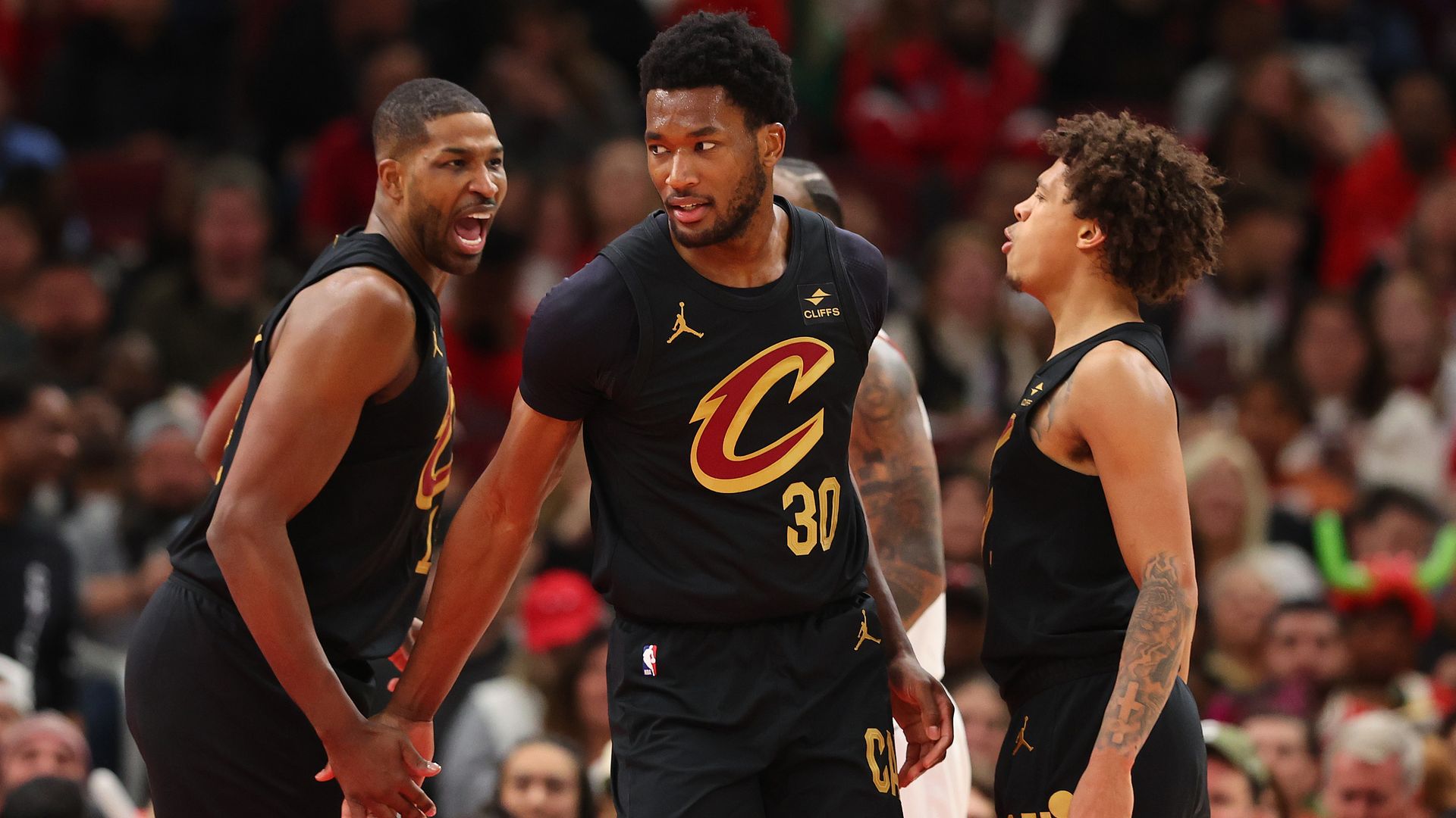 The Cavs' Tristan Thompson, Damian Jones and Craig Porter, Jr. in black jerseys.