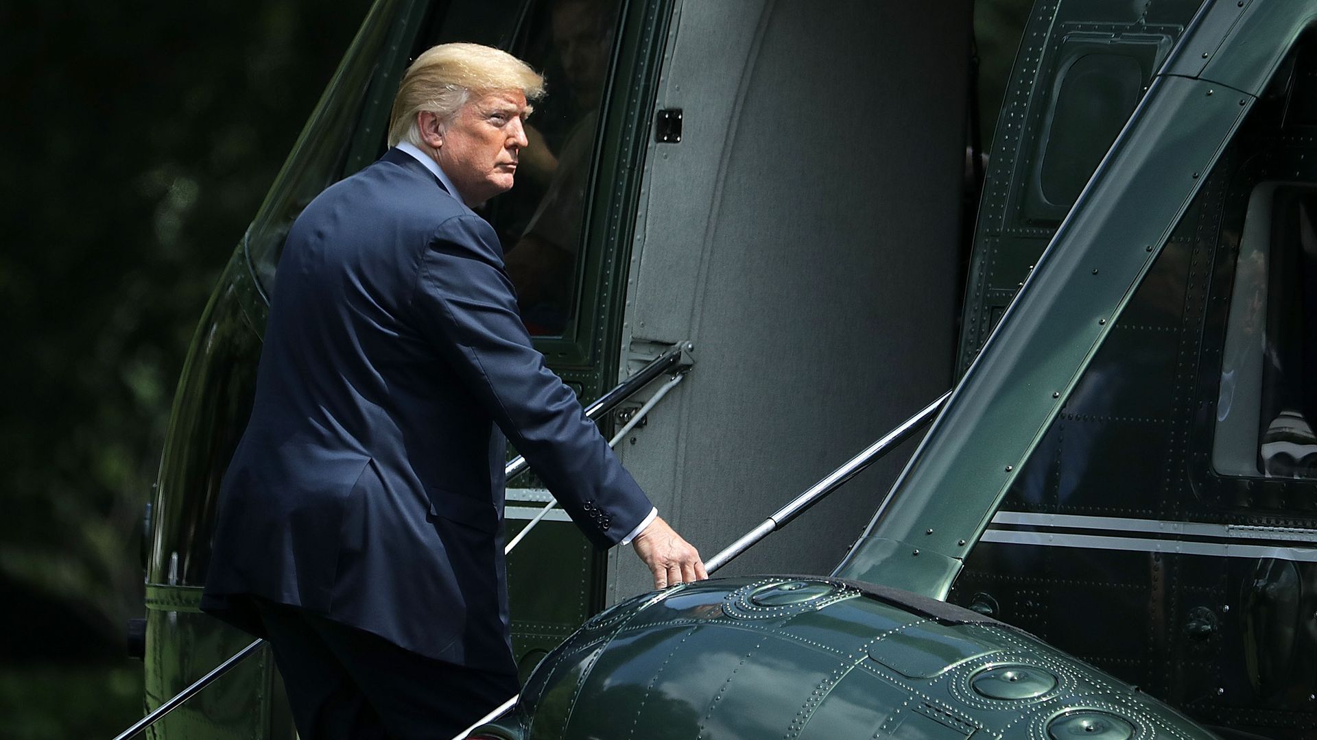 President Trump looks out as he climbs the stairs onto Marine One