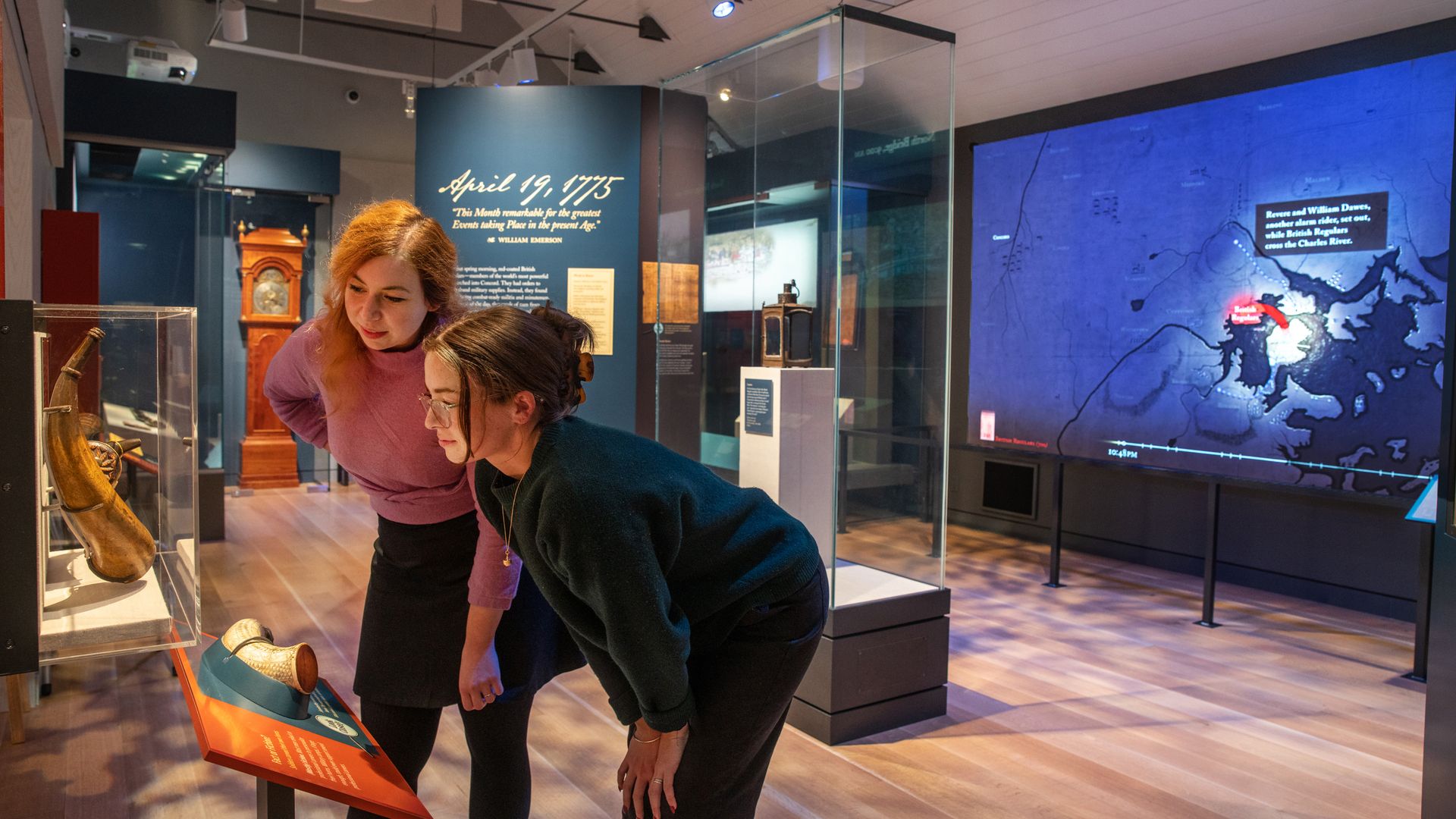 Two women look at the late Abner Hosmer's horn on the left side of the Concord Museum. Hosmer died in the first firing at North Bridge in Concord.