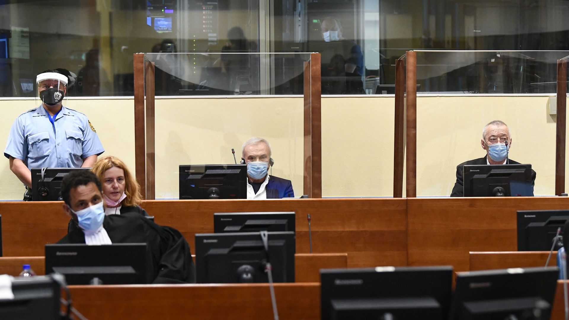 Jovica Stanisic and Franko "Frenki" Simatovic behind glass partition at their Hague trial in June