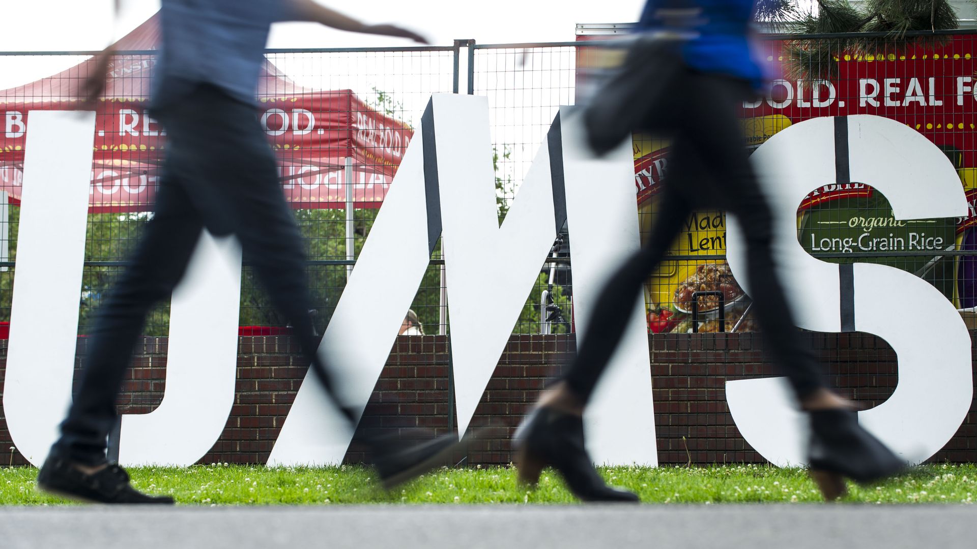 People walk past the UMS (Underground Music Showcase) sign along South Broadway.