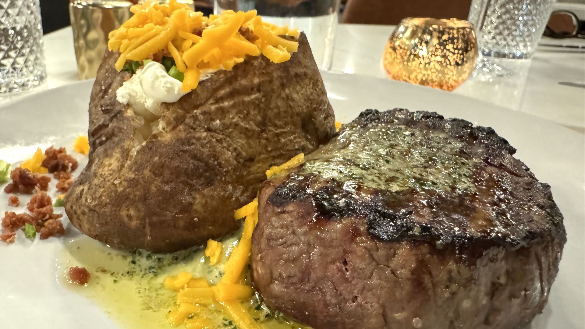 A plate with a steak and baked potato.