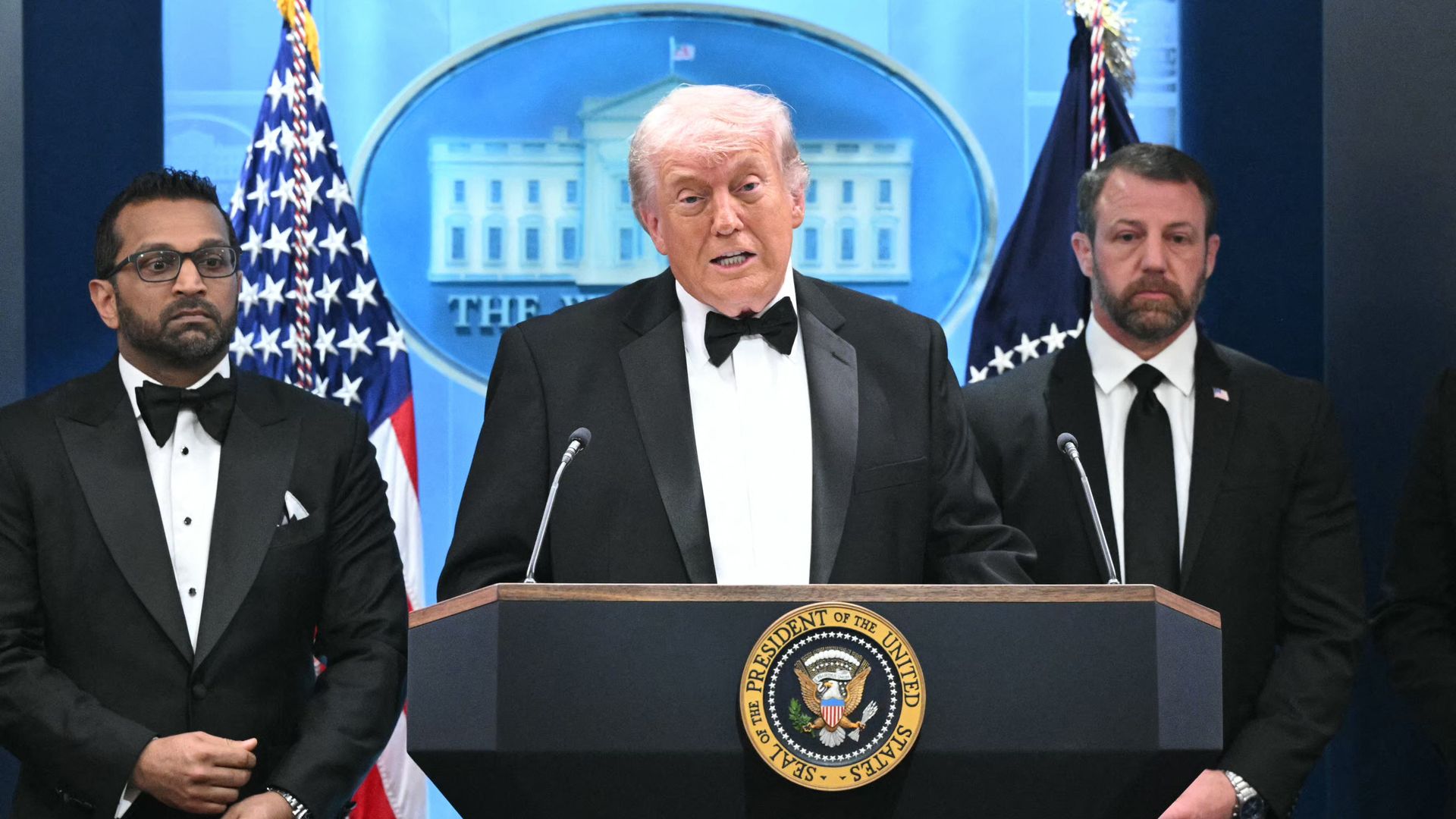 President Trump, in a tuxedo, speaks from a podium bearing the White House seal.