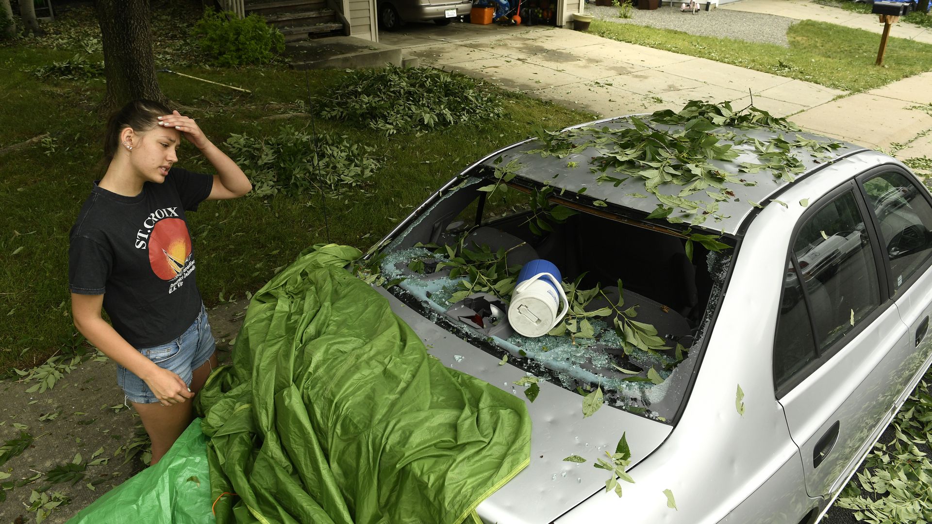 Sara Pilot, left, looks at the hail damage to her father's car outside of her home in Louisville in 2018. Photo: Helen H. Richardson/The Denver Post via Getty Images