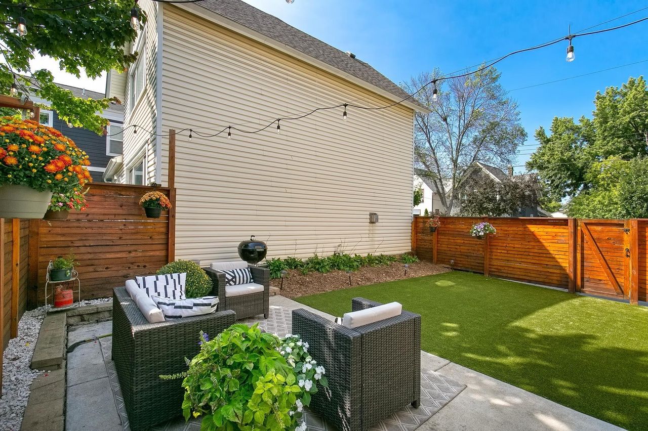 backyard with string lights, turf and deck