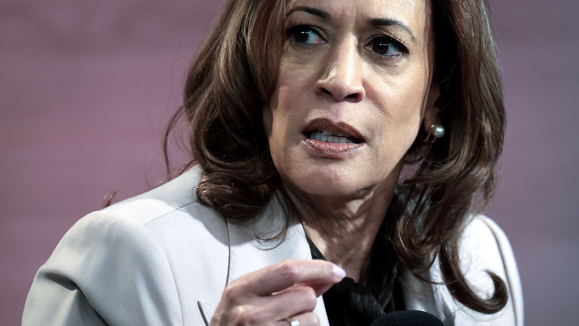 Kamala Harris, wearing a light-colored jacket, looks to her right.