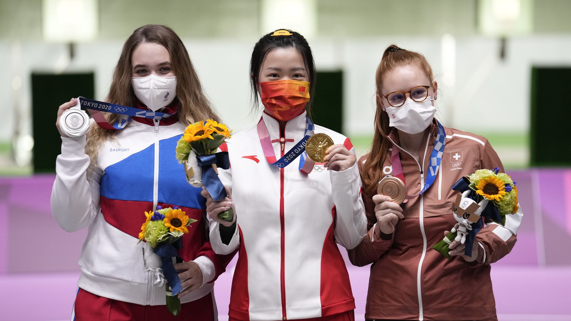 Silver medalist Anastasiia Galashina of Russia, gold medalist Yang Qian of China and bronze medalist Nina Christen of Switzerland celebrate on the podium after the 10m Air Rifle Women's Final