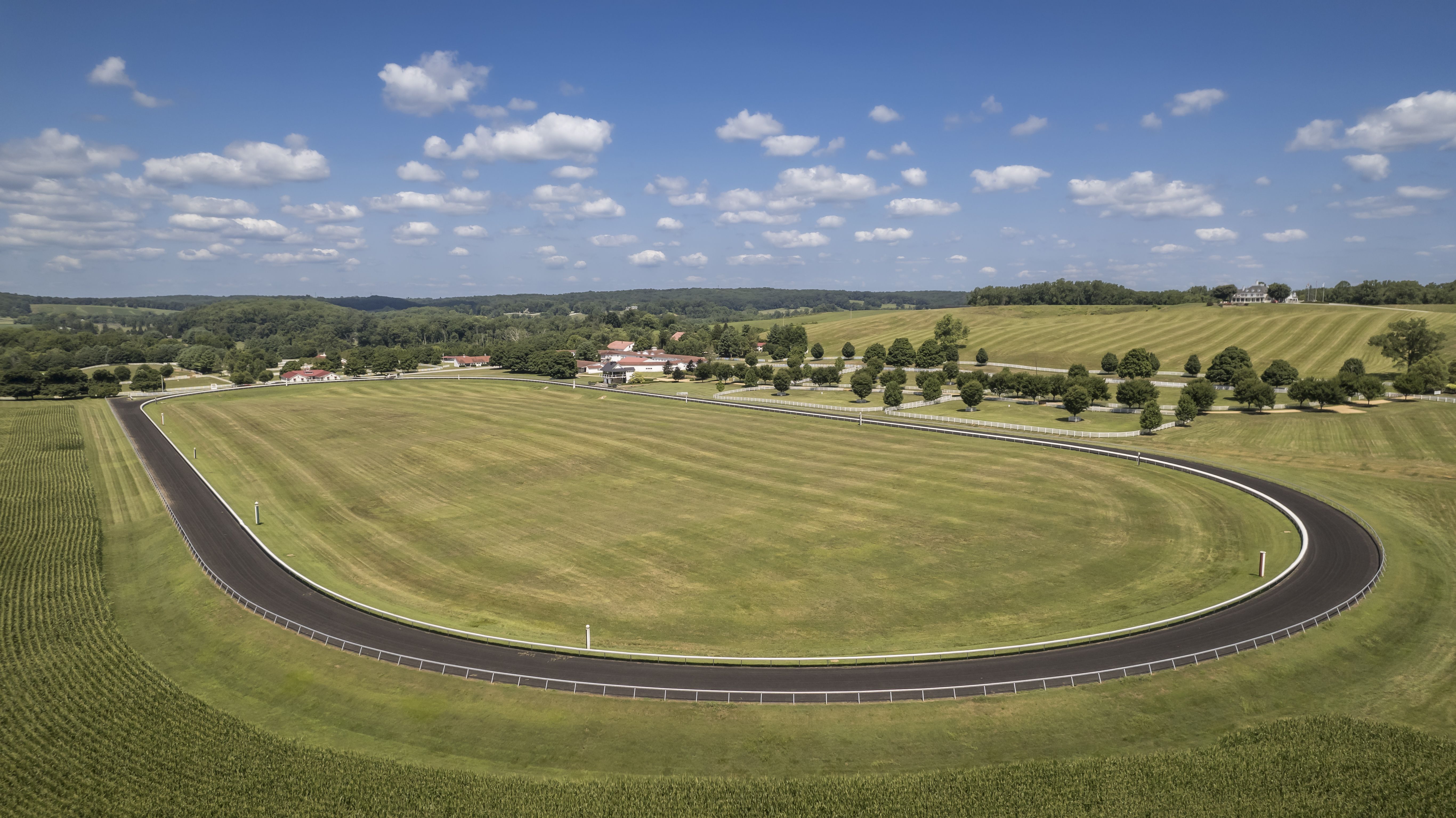 An aerial photo of a large horse track surrounded by green farmland.