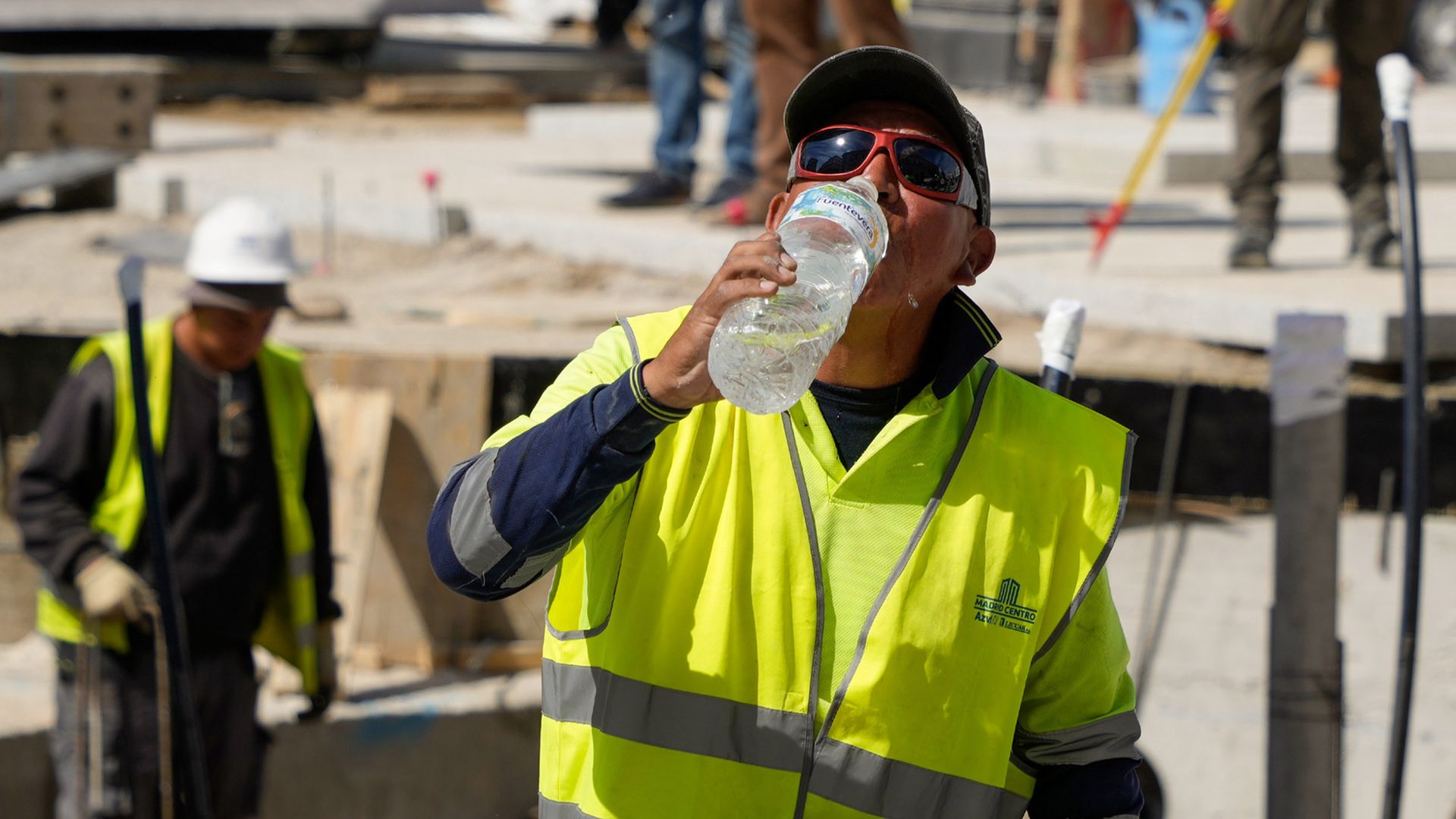 A construction worker drinks bottled water during a heat wave in Spain.