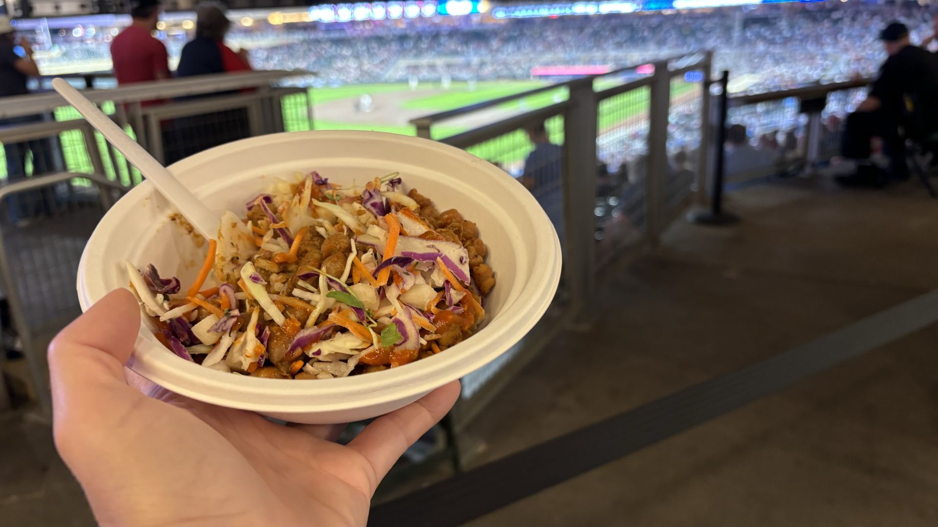 A hand holding a bowl of food