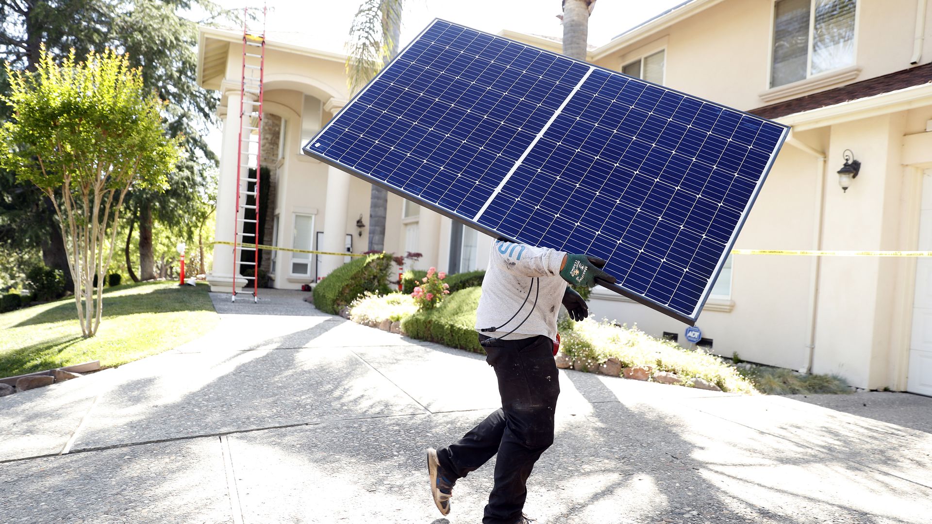A person carrying a solar panel into a home in a home in Alamo, California, in May 2017.