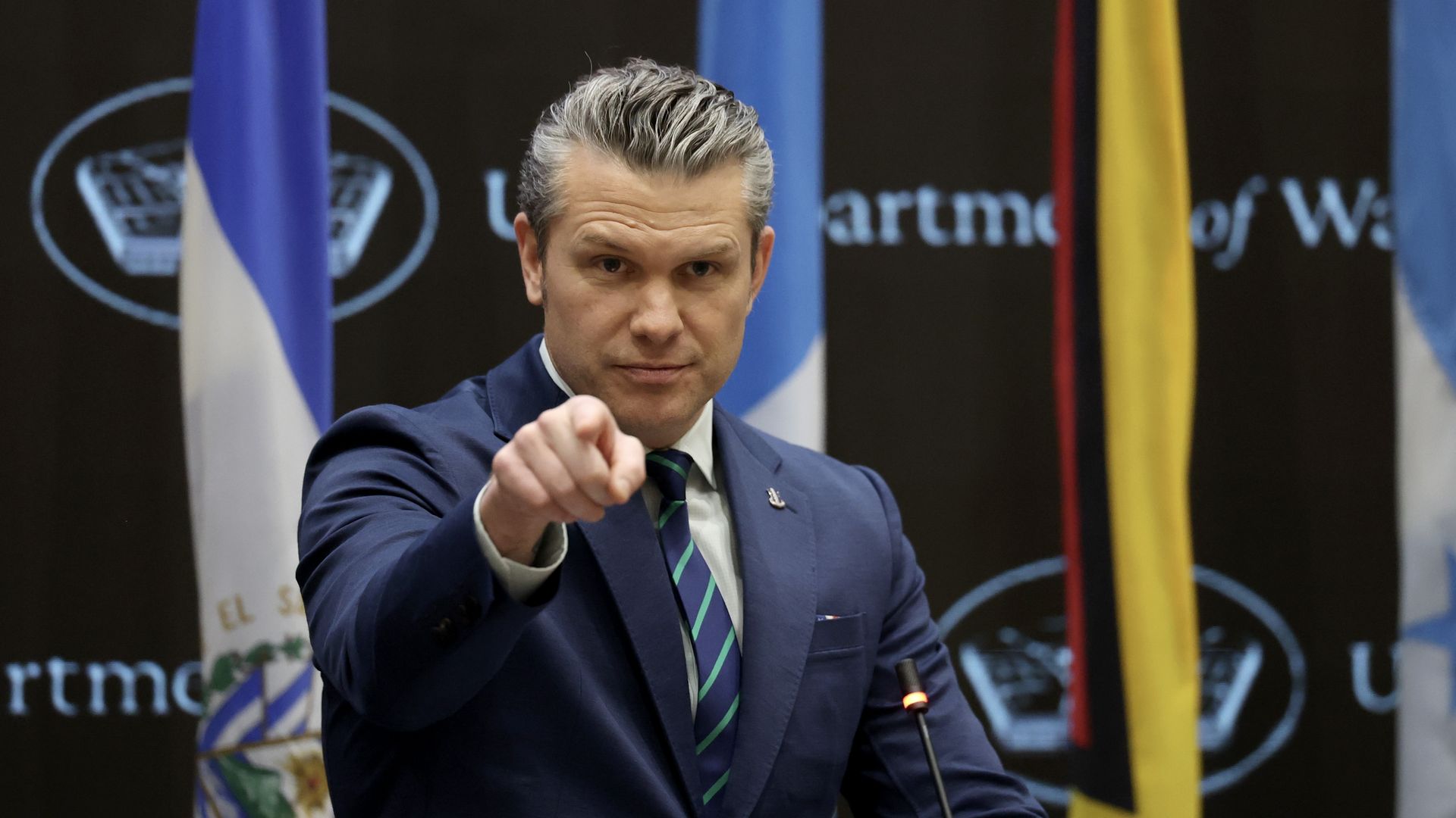 Man at podium points forward