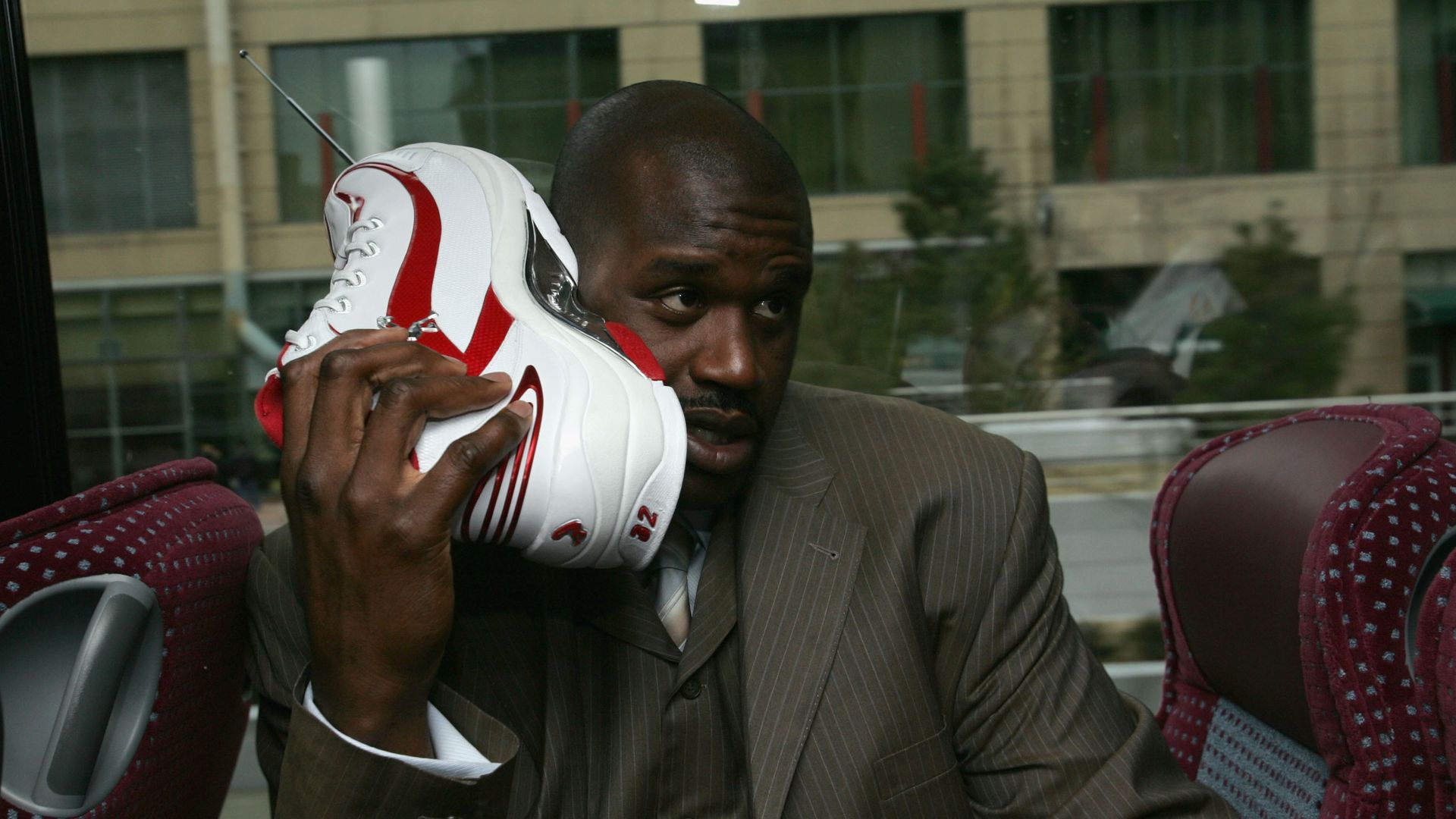 Shaquille O'Neal of the Eastern Conference All-Stars talks on his sneaker phone as he rides the bus to the Arena for the 54th All-Star Game