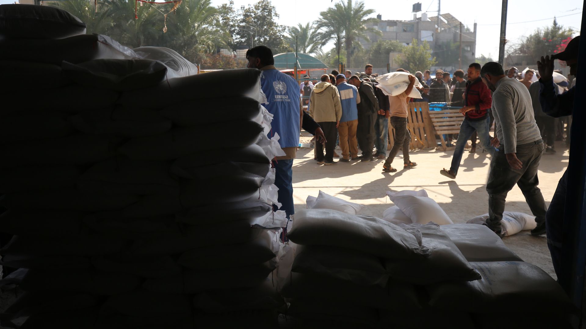 Palestinians are receiving bags of flour for humanitarian aid distribution in Bureij camp in the central Gaza Strip on November 30, 2023. 