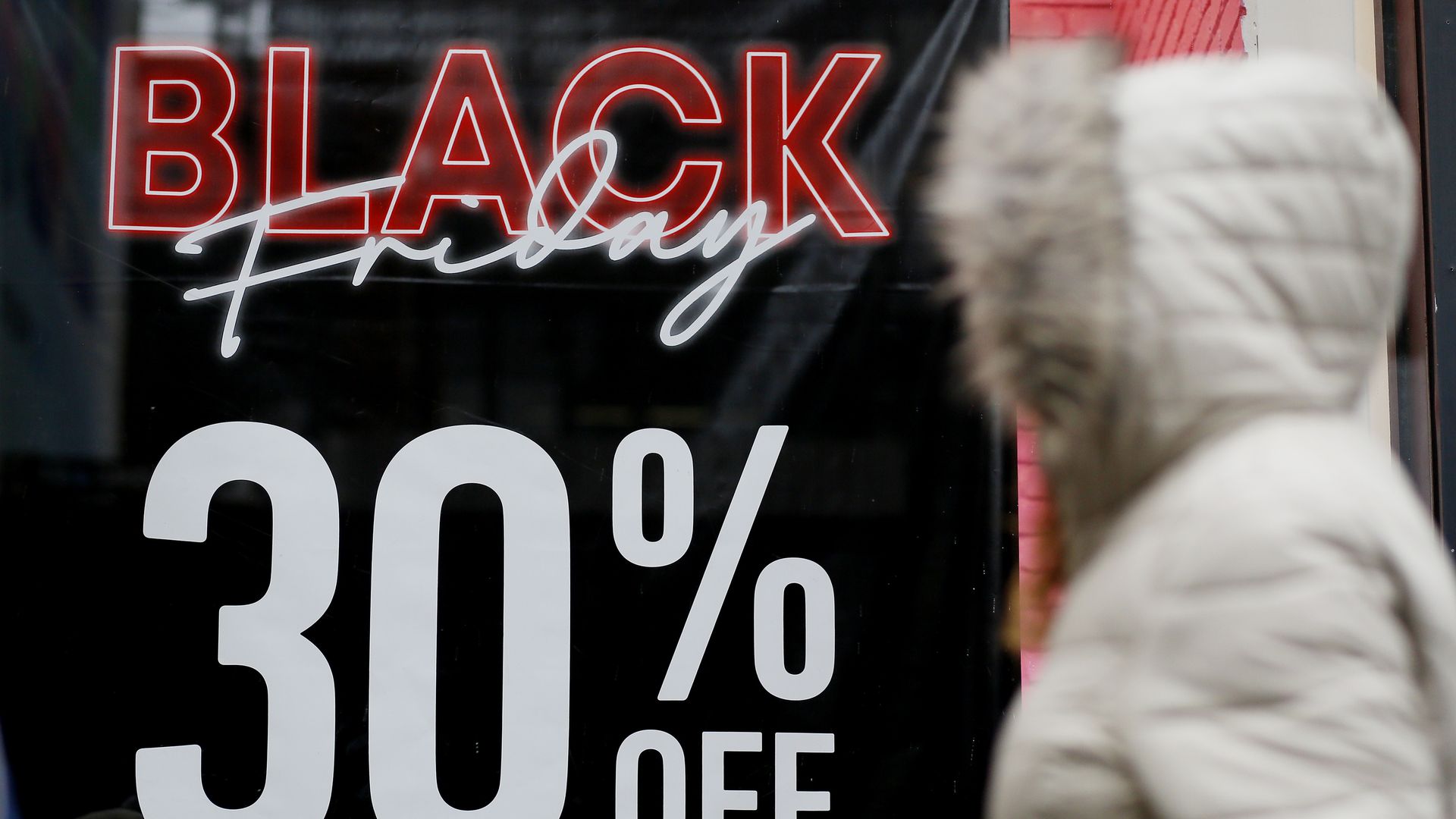 Shopper walks by a sign that says Black Friday 30%
