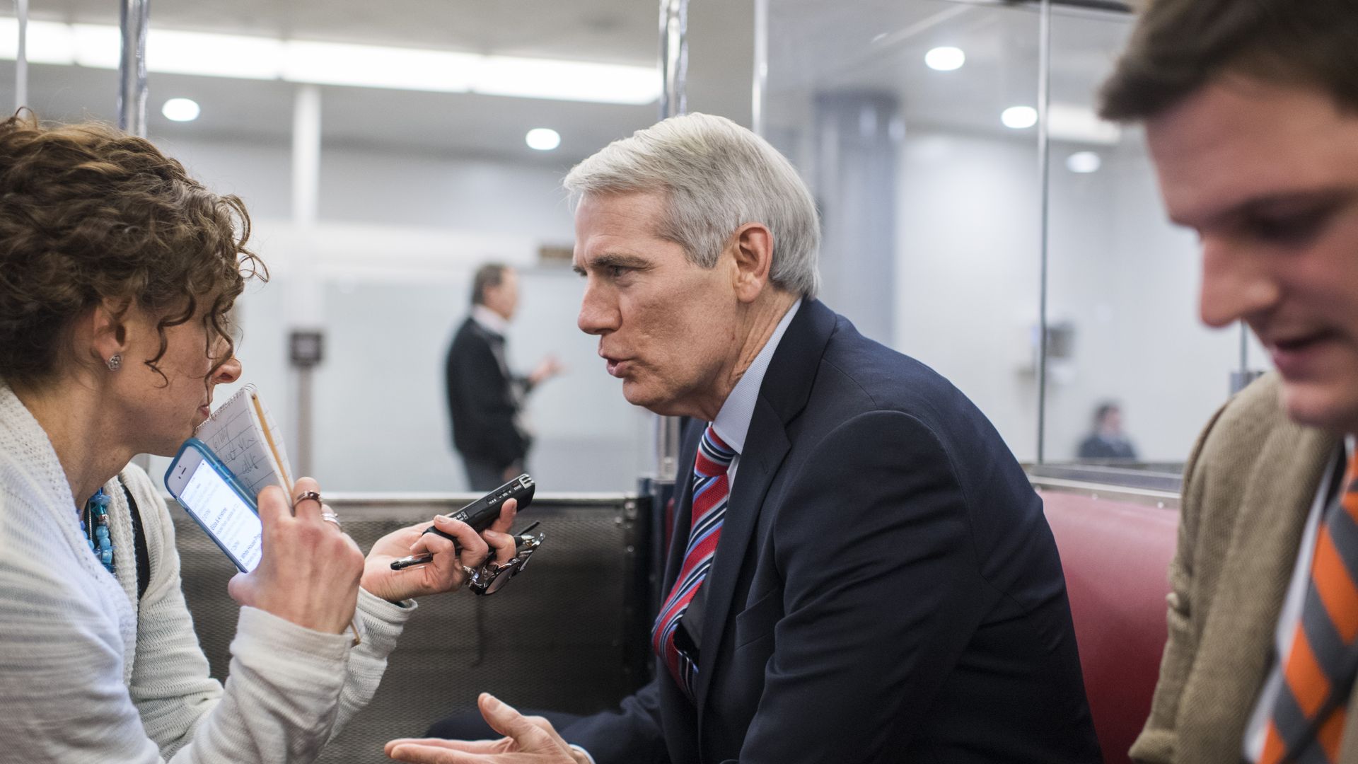 Senator Rob Portman talks to reporters on a train