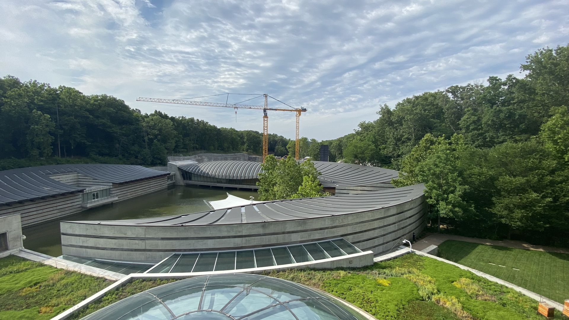 A photo of the rooftops of Crystal Bridges Museum of American Art with a crane in the background. 
