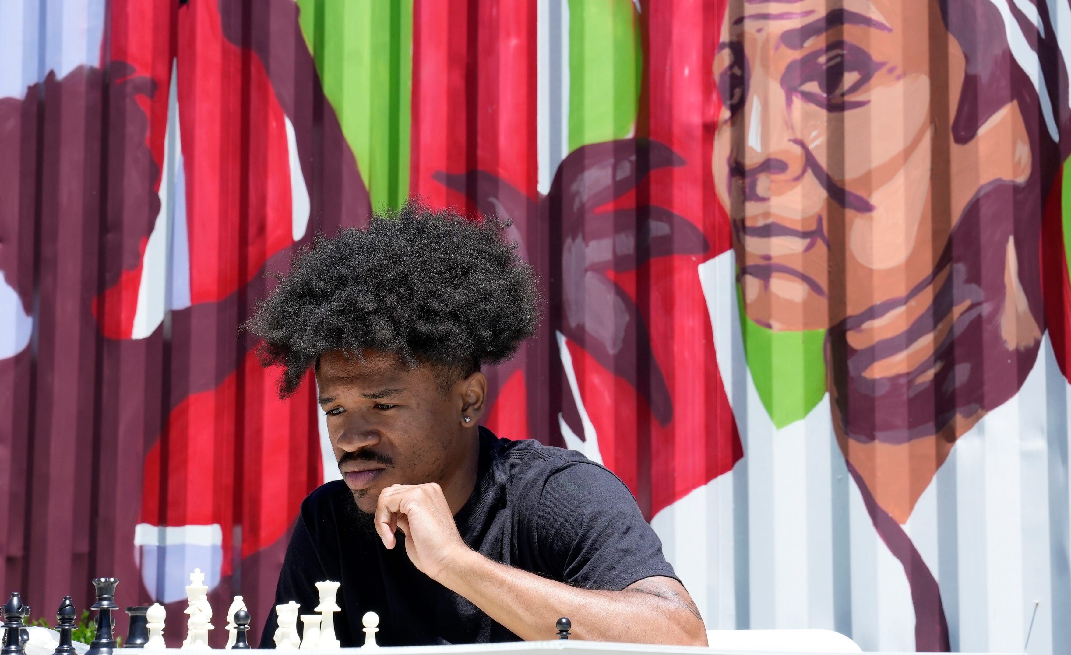 A man concentrates while looking at a chess board