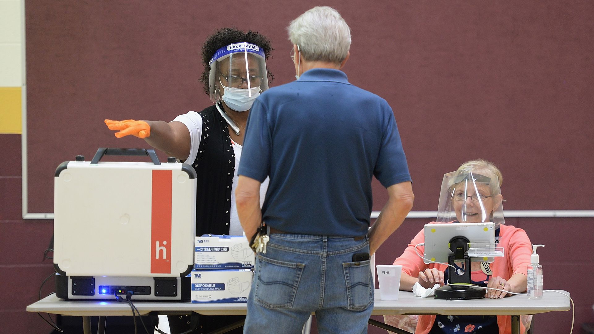 A poll worker helps a voter access his ballot at Keevan Elementary School August 4, 2020 in St. Louis, Missouri.