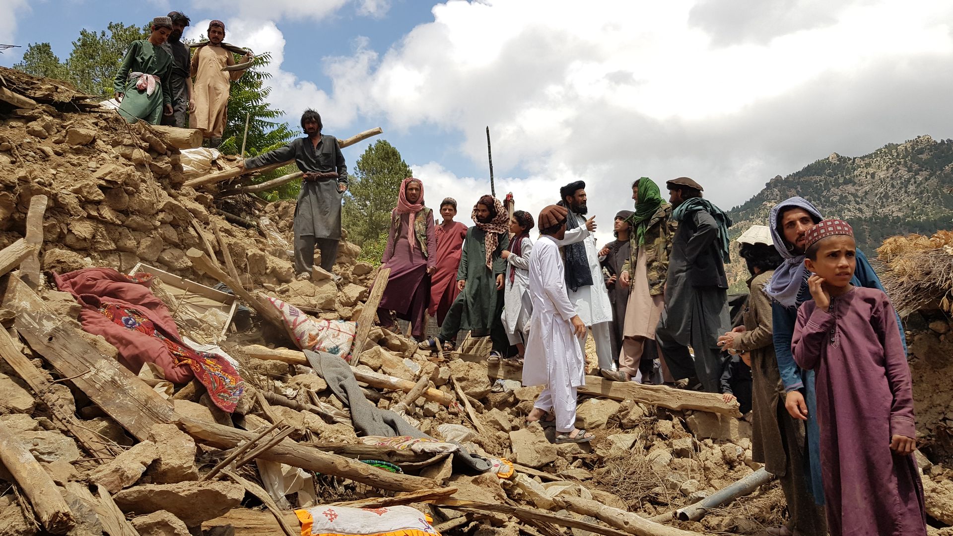 People help for the search and rescue operations on debris of a building after an earthquake shook Afghanistan on June 22.