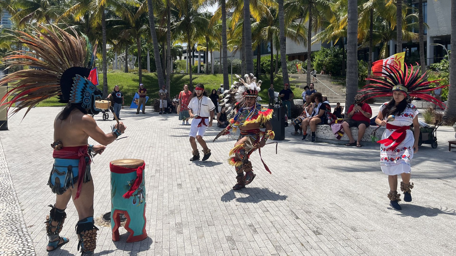 Native American protesters dressed in traditional garments do a performance.