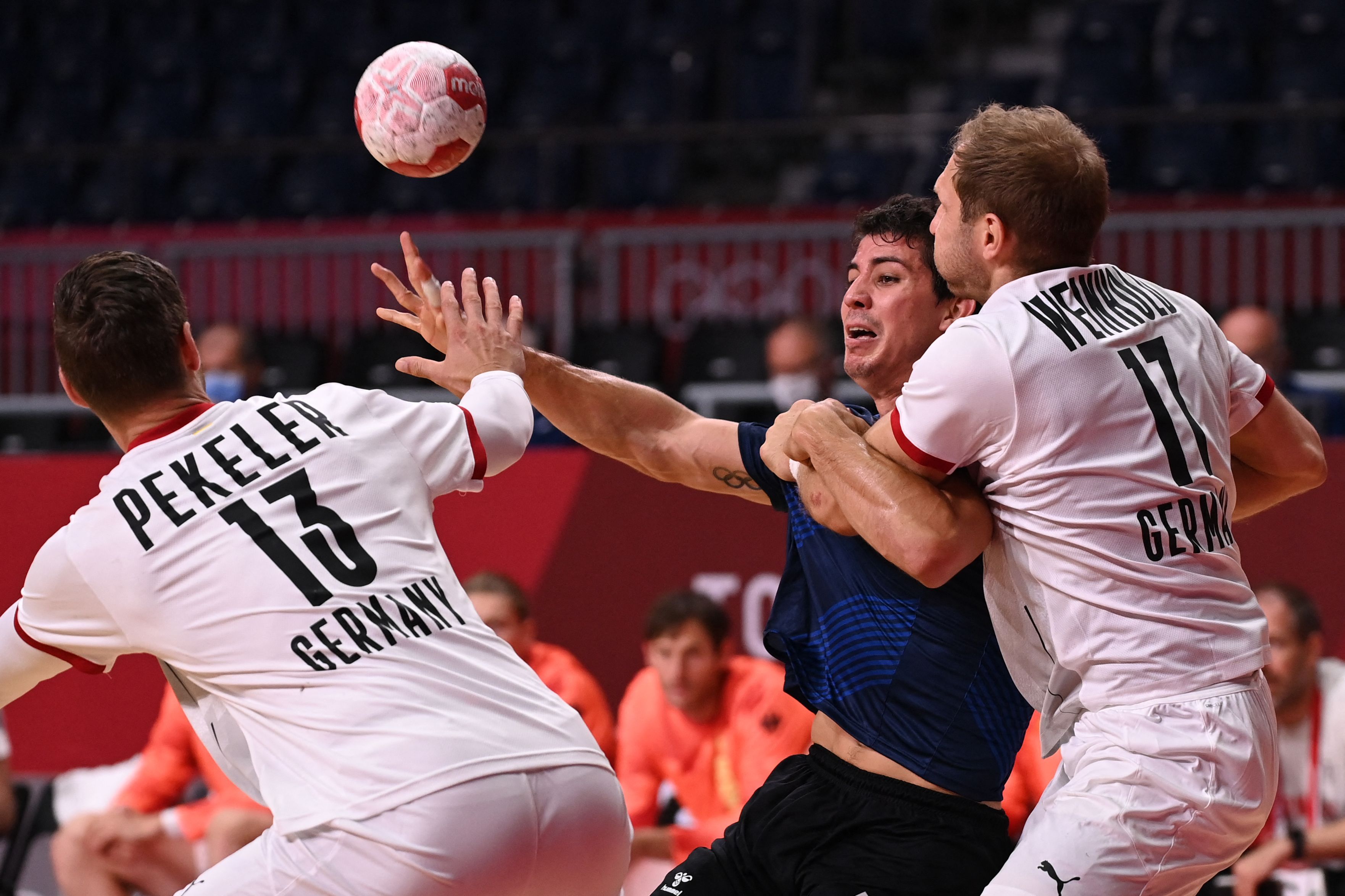 Argentina's centre back Diego Simonet (C) is challenged in the men's Preliminary Round Group A handball match between Argentina and Germany at the Tokyo Games