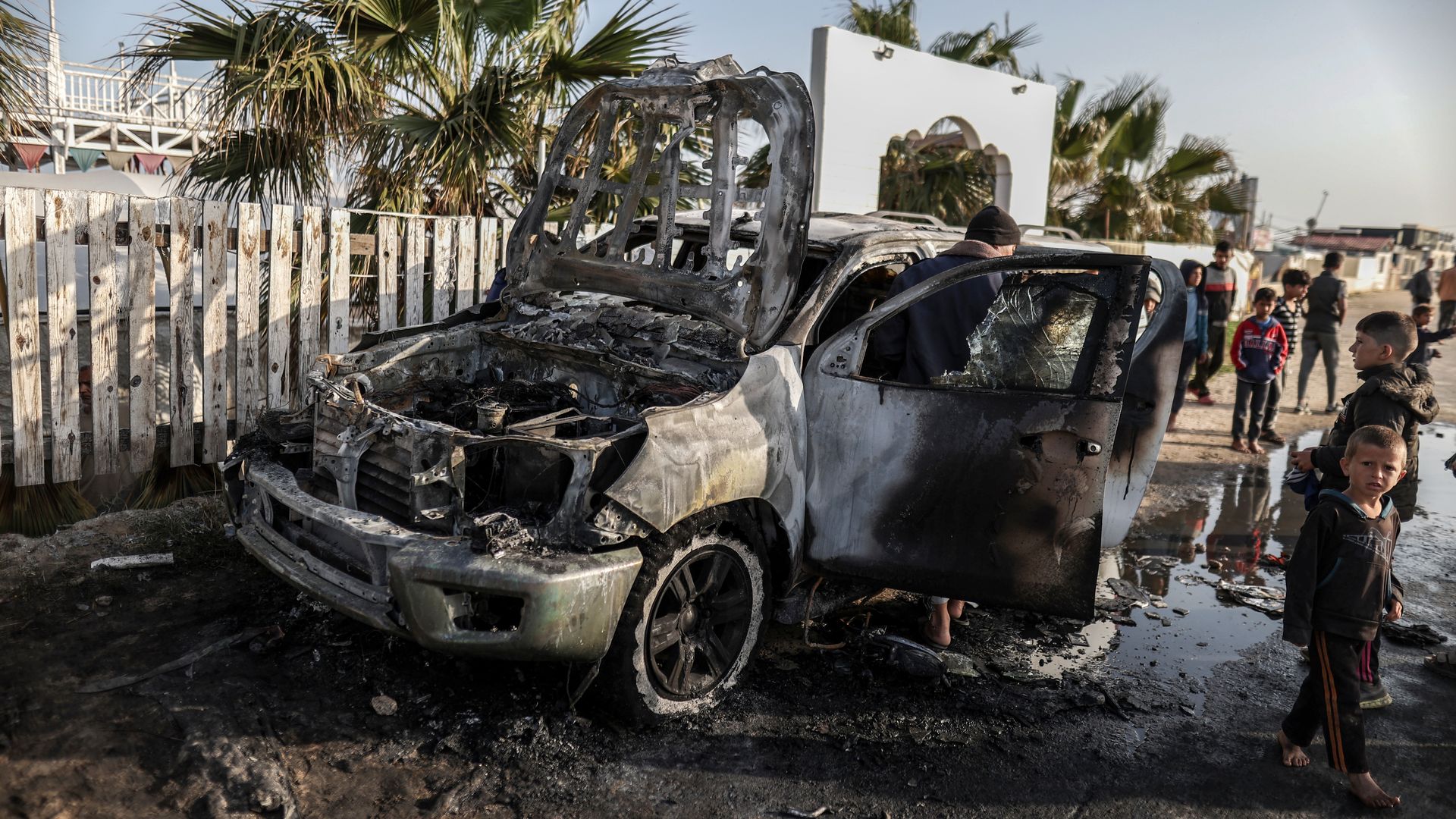 Residents inspect the damaged vehicle damaged vehicle carrying Western employees after Israeli attack in Deir al-Balah, Gaza on April 02, 2024. 