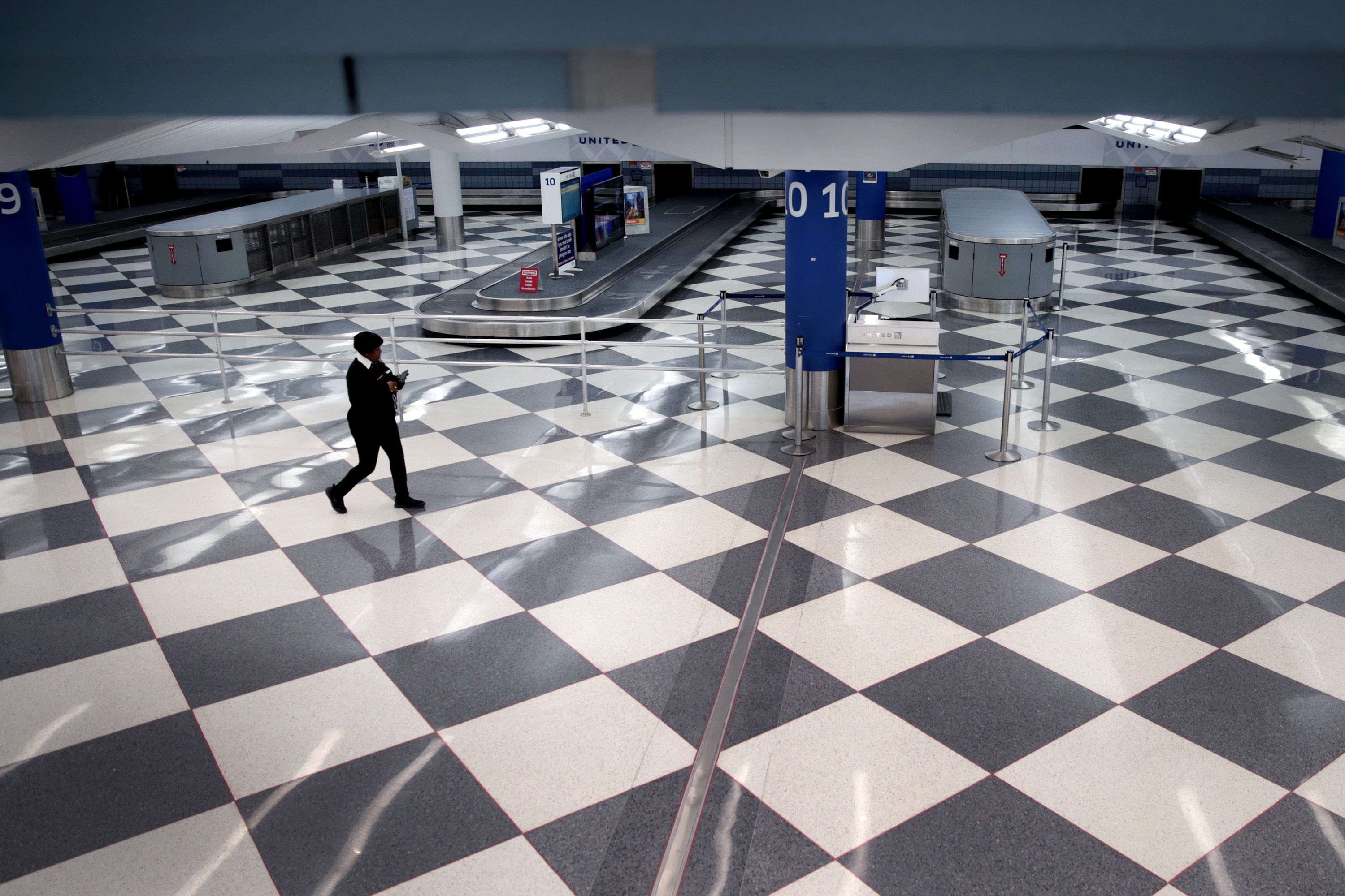 A worker walks through a baggage claim area at a nearly-empty O'Hare International Airport on April 2