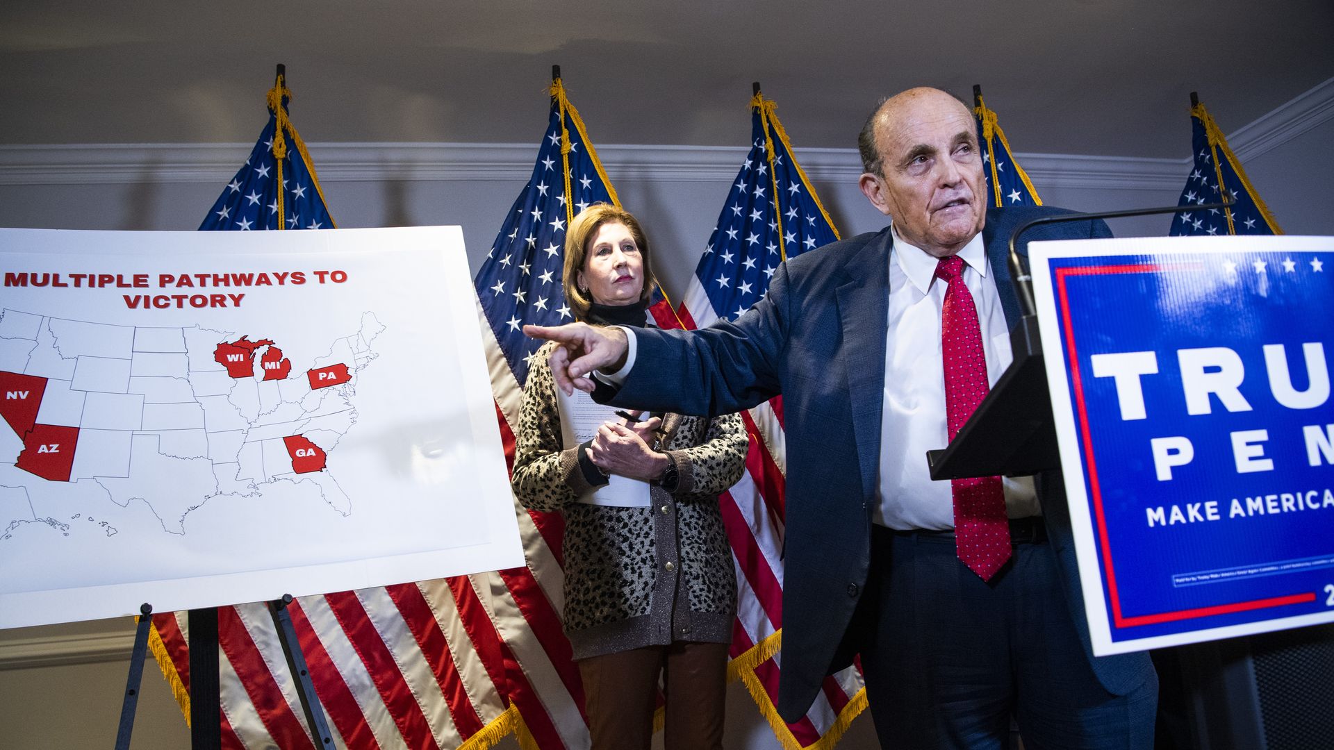 Photo of Rudy Giuliani and Sidney Powell standing at a Trump/Pence podium