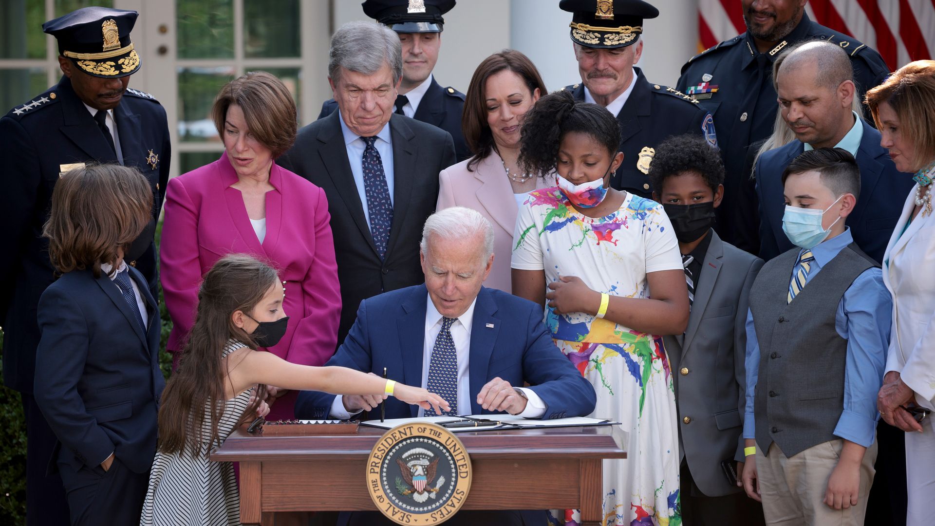 Biden, surrounded by a crowd, signs legislation to award congressional gold medals to law enforcement