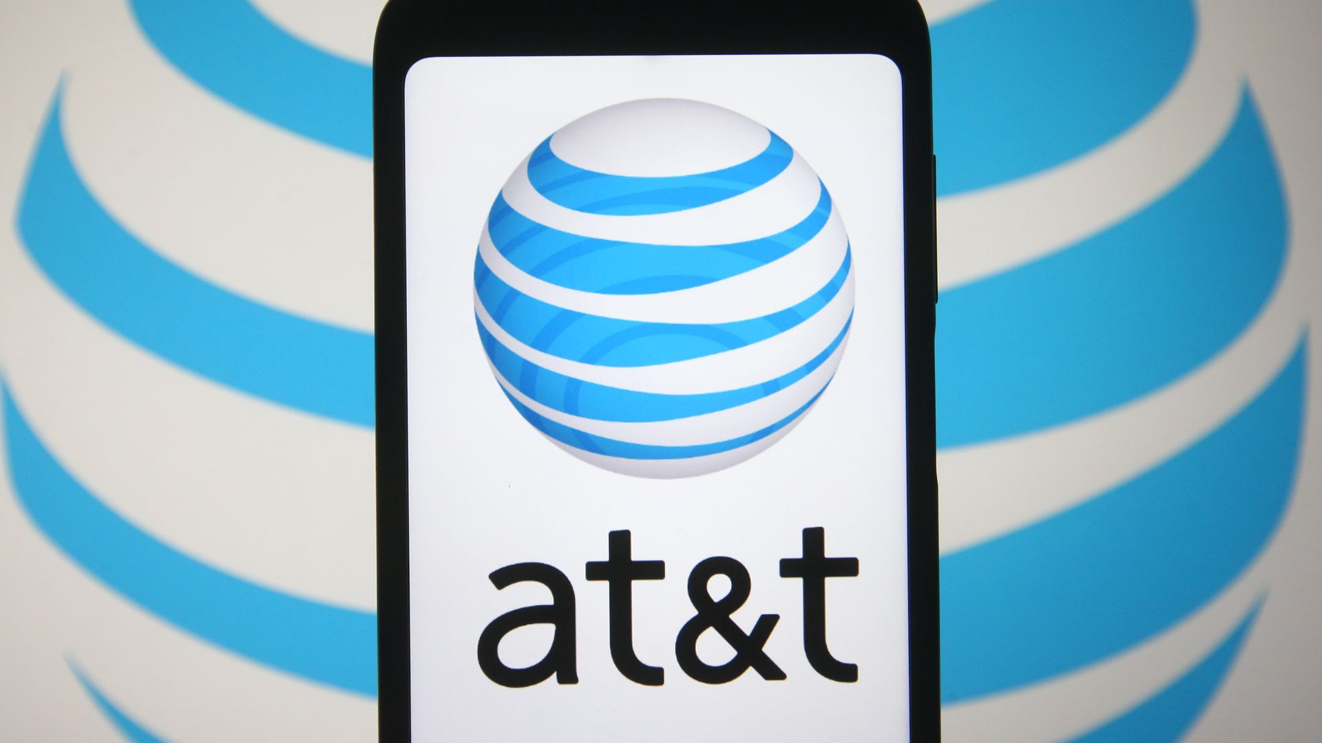 Image of AT&T logo on a phone screen in front of another AT&T logo