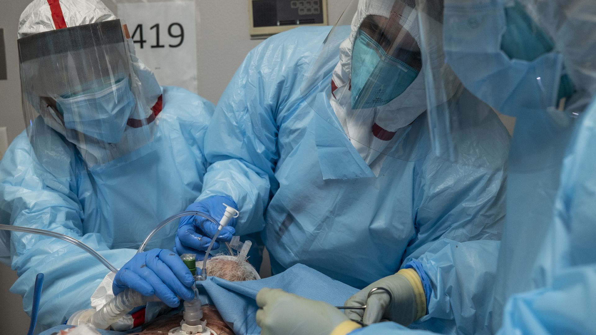 Medics work to install a ventilator circuit on a patient's throat in a COVID-19 intensive care unit in Houston.