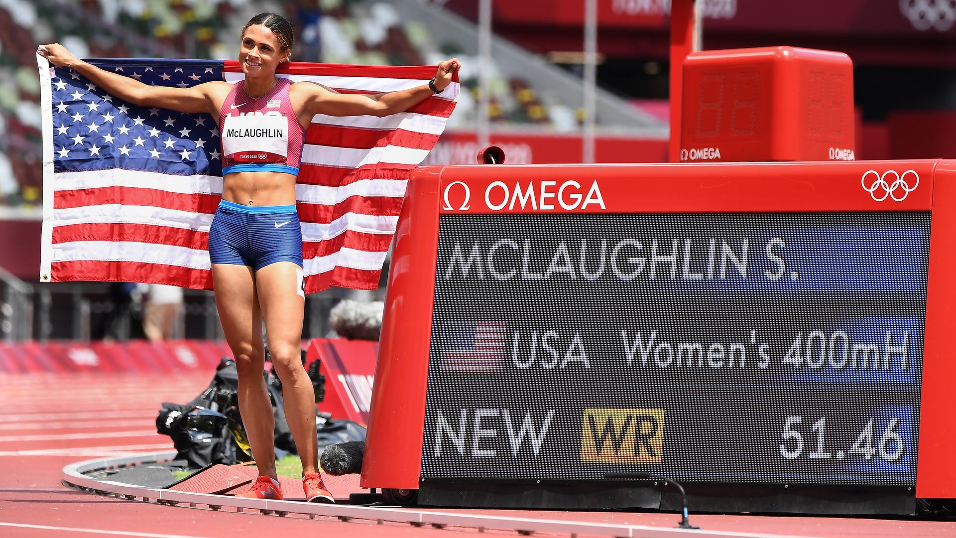 USAs Sydney McLaughlin poses in front of the timer after winning the 400m hurdles in record time at the 2020 Tokyo Olympics.